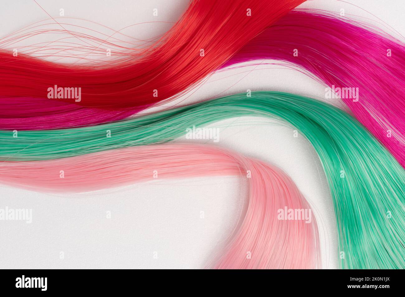 Bunte Haarfäden auf weißem Studiohintergrund isoliert Stockfoto