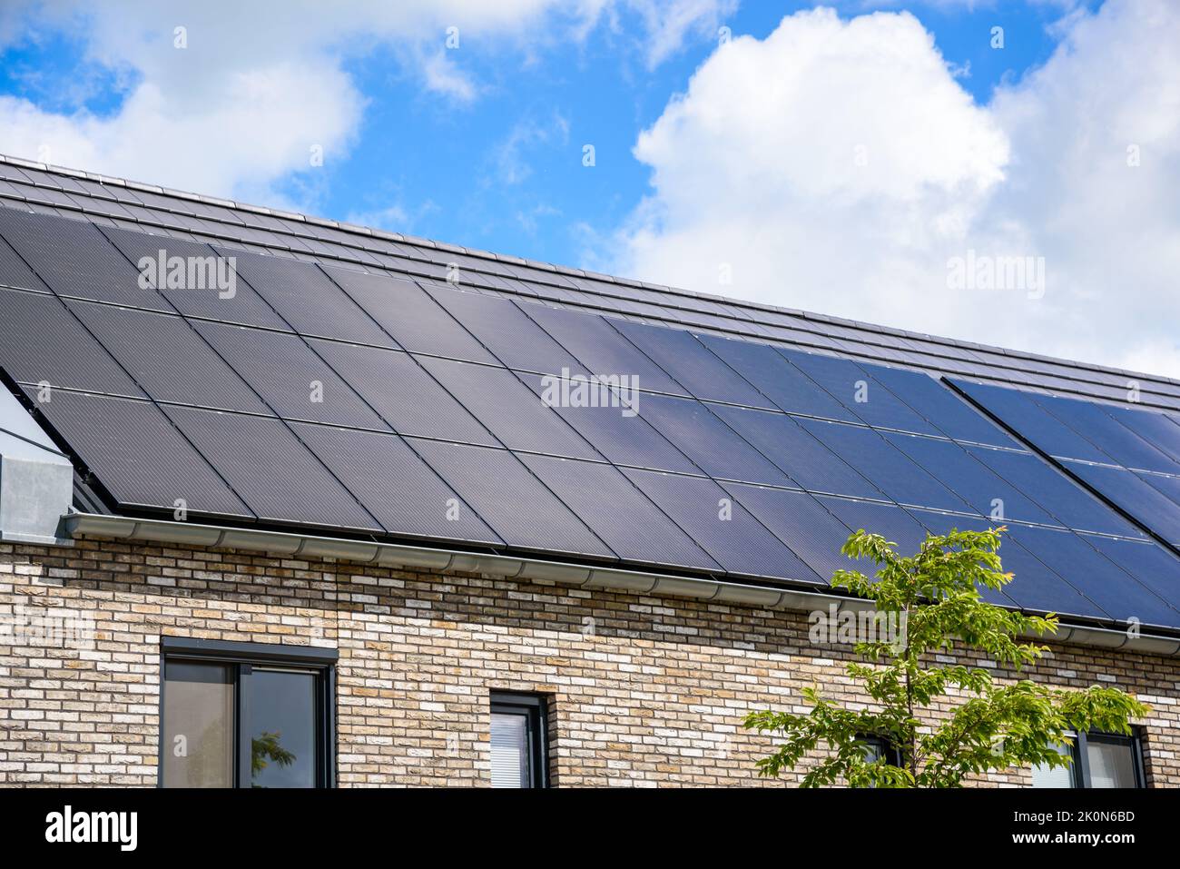 Nahaufnahme des Daches von energieeffizienten Reihenhäusern, die mit Sonnenkollektoren für die Stromerzeugung bedeckt sind Stockfoto