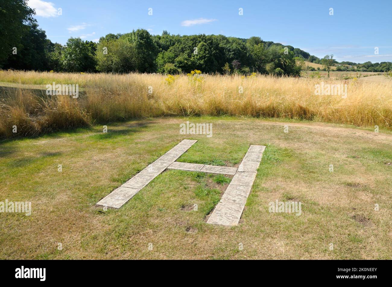 Ein Hubschrauberlandeplatz (Hubschrauberlandeplatz), der auf dem Land markiert ist, wo ein einzelner Hubschrauber starten oder landen kann, gekennzeichnet durch einen Buchstaben „H“. Stockfoto