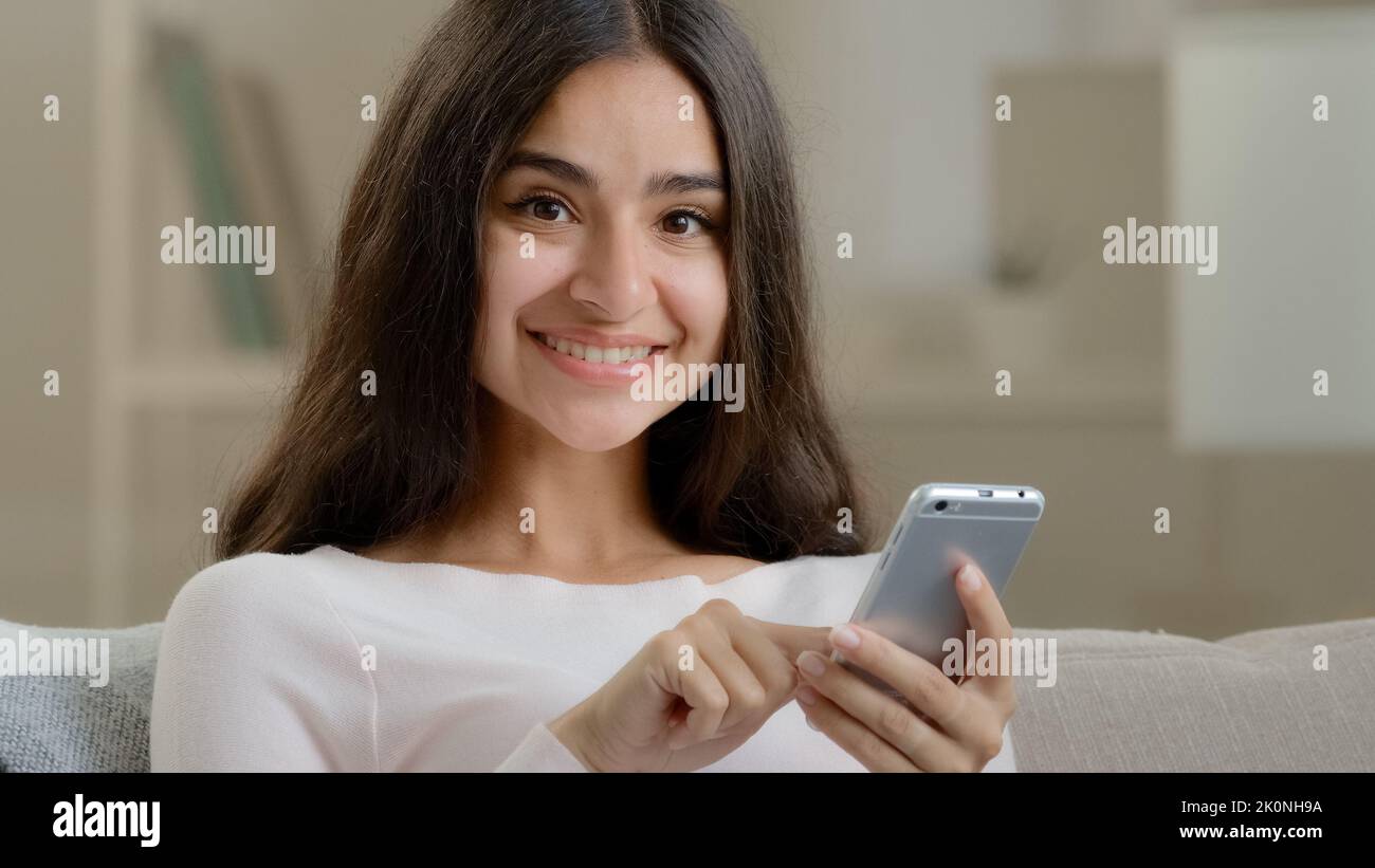 Arabian latin glücklich Frau Brünette Mädchen junge Freiberufler Benutzer scrollt mobile Schnittstelle Klicken Smartphone Anzeige scrollen Bilder chatten wählen Stockfoto