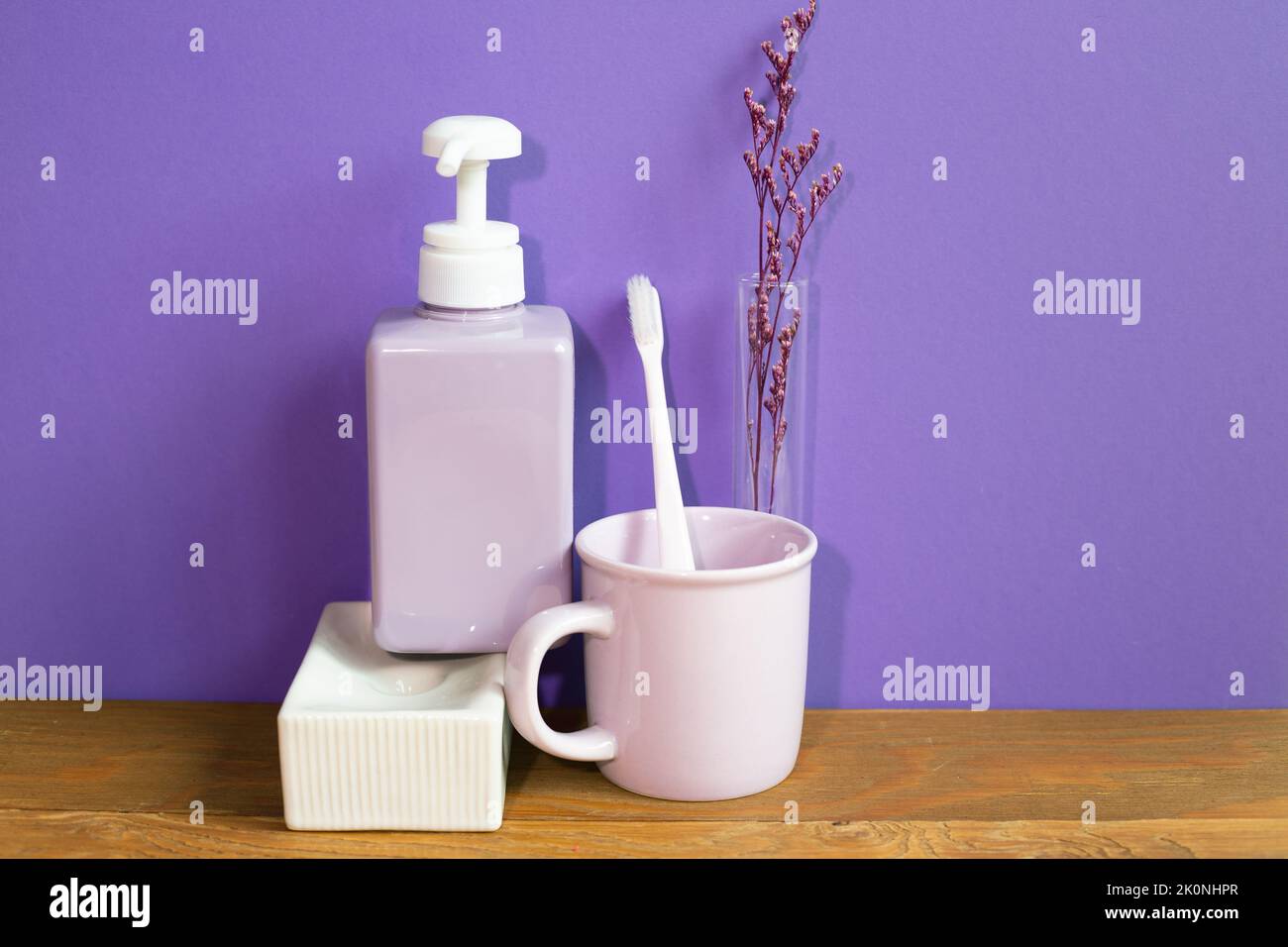 Bad-Accessoires Hygiene-Objekte auf Holztisch. Lila Wand Hintergrund Stockfoto