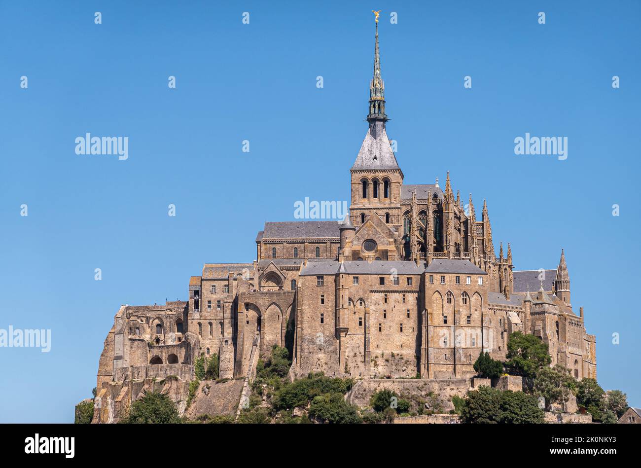 Mont St. Michel, Normandie, Frankreich - 8. Juli 2022: Nahaufnahme des religiösen Teils aus braunem Stein, der Abtei und der Kirche auf dem Felsen vor blauem Himmel. Stockfoto