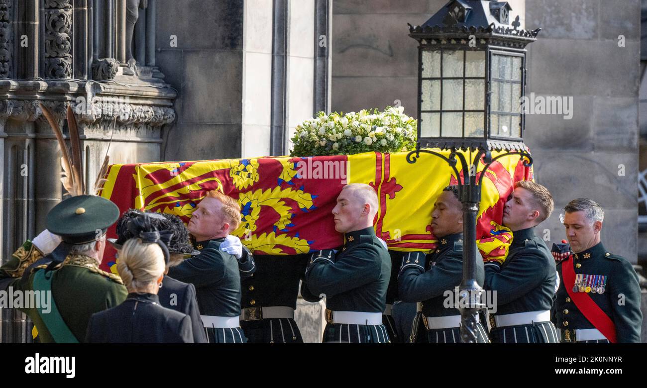 Edinburgh, Schottland. VEREINIGTES KÖNIGREICH. 12. September 2022. Der Sarg von Königin Elizabeth II., der mit dem Royal Standard of Scotland und einem Blumenkranz aus dem Balmoral-Anwesen geschmückt ist, wird in die St. Giles Cathedral getragen. Quelle: Anwar Hussein/Alamy Live News Stockfoto