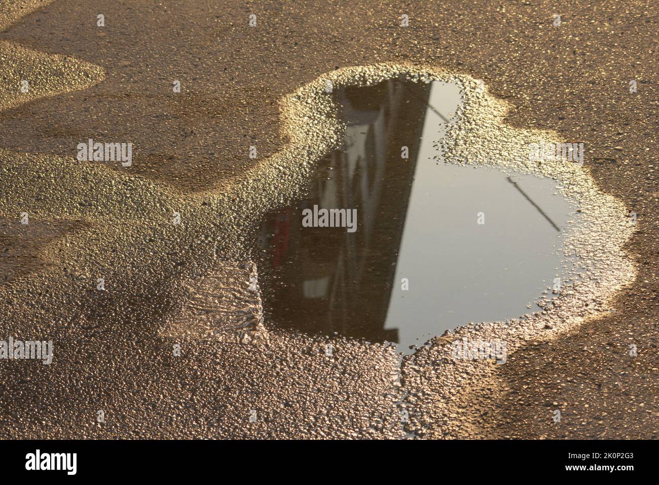 Kleiner Teich an der Straße mit Gebäudespiegelung. Stockfoto