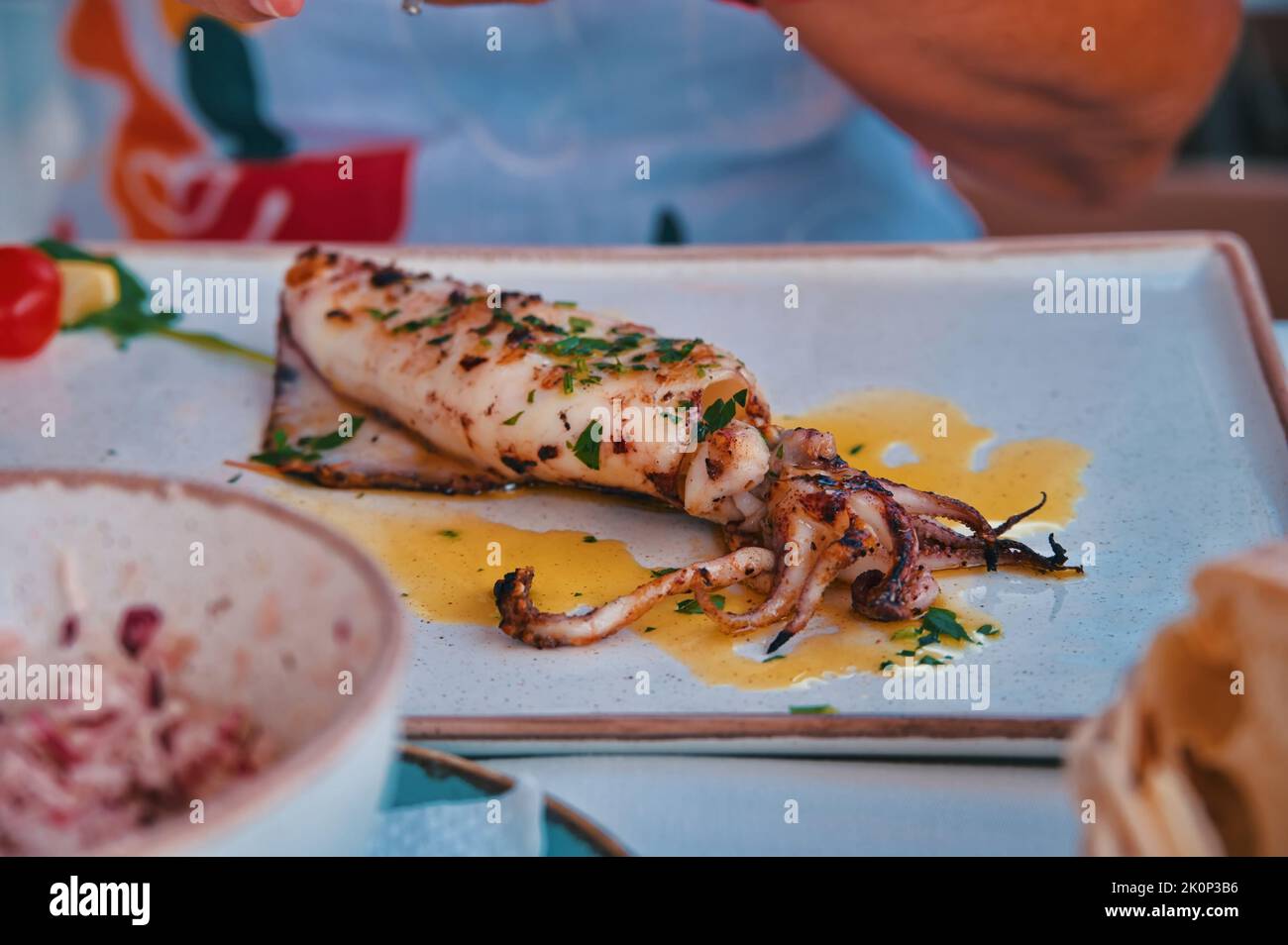 Im Restaurant wird Calamari auf dem Tisch serviert Stockfoto