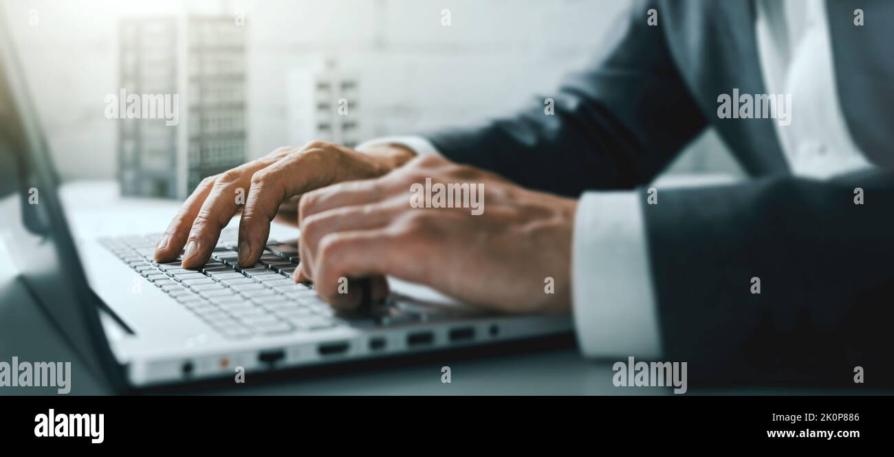 Nahaufnahme der Hände des Geschäftsmannes, die im Büro auf einem Laptop tippen. Banner Stockfoto