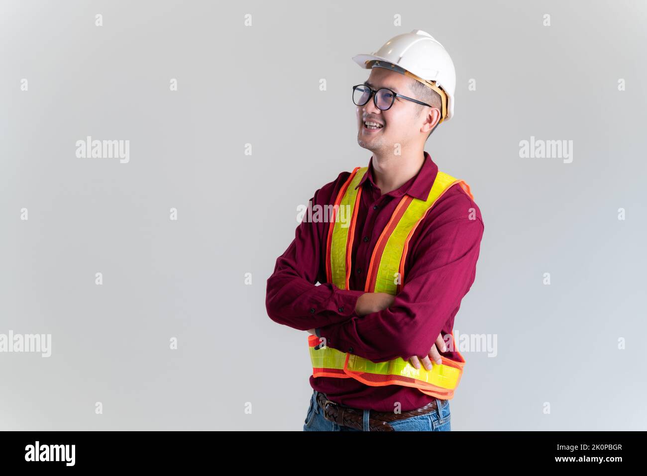 Porträt eines glücklichen jungen Vorarbeiters mit Hut in einem Studio. Architekt, Ingenieur, Baukonzept. Stockfoto