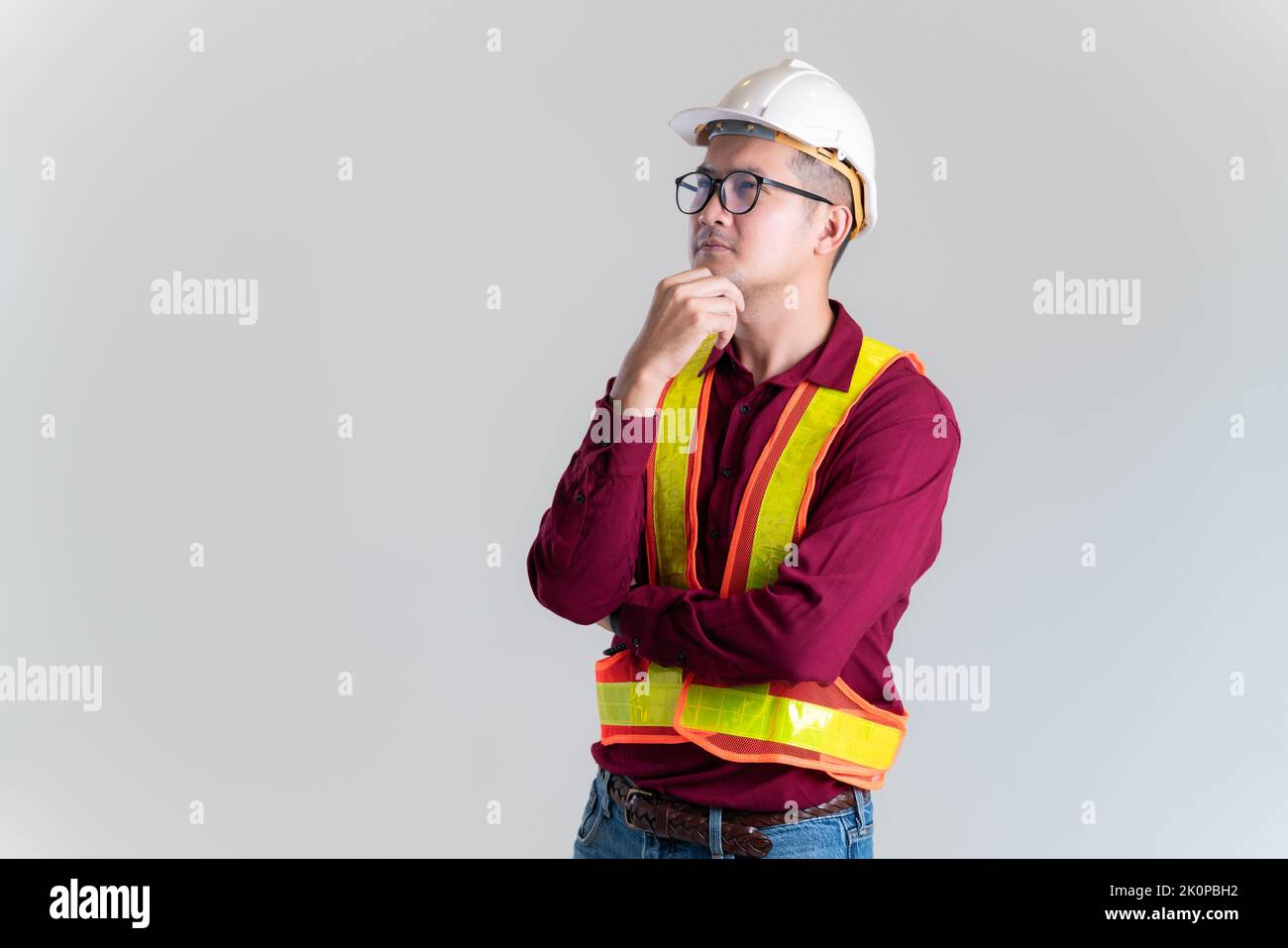 Porträt eines asiatischen Ingenieurs, der in einem Studio einen Hardhut trägt und gegen den er posiert. Architekt, Ingenieur, Baukonzept. Stockfoto