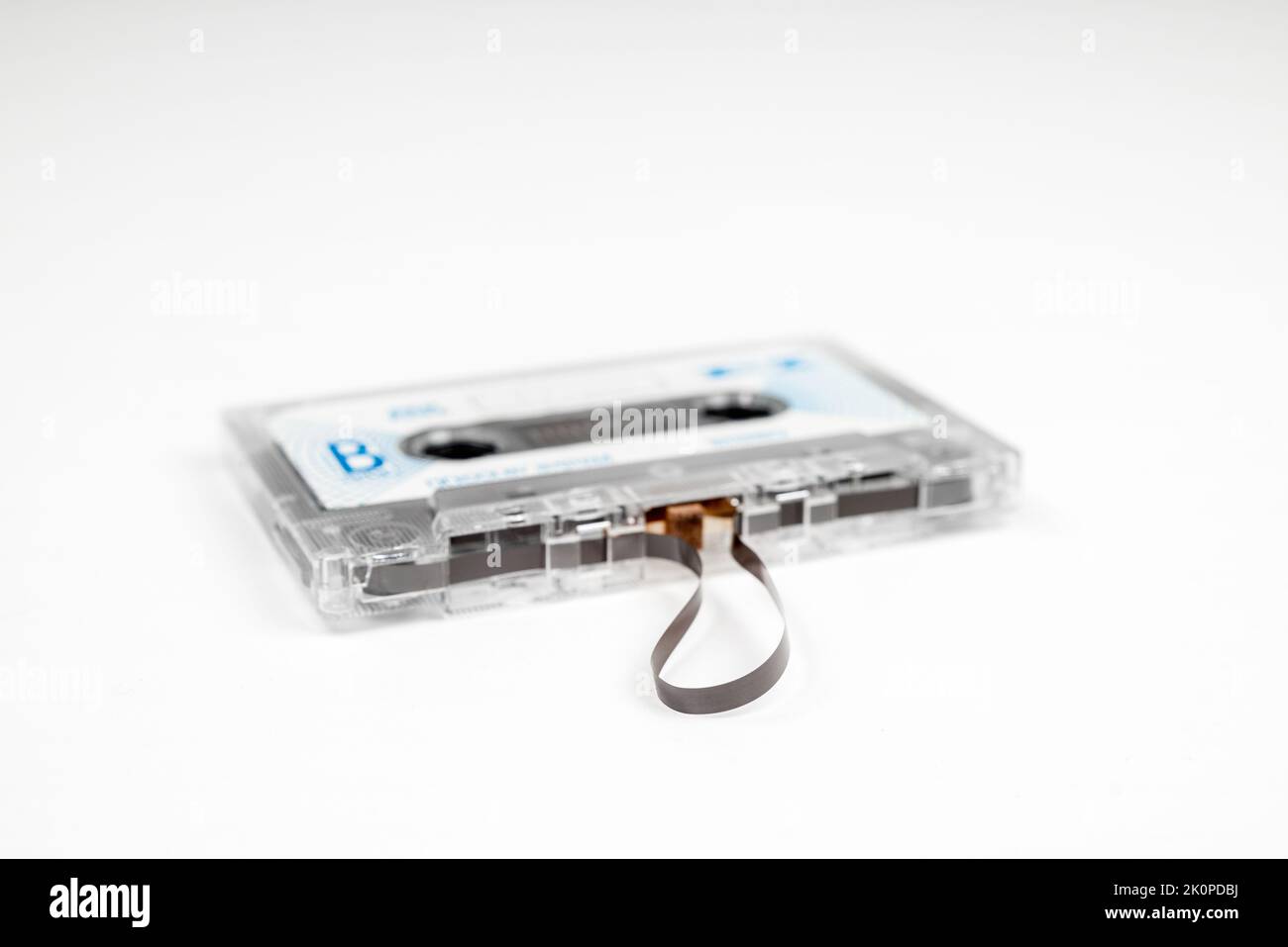 Alte Audiokassette mit losem Klebeband auf weißem Hintergrund Stockfoto
