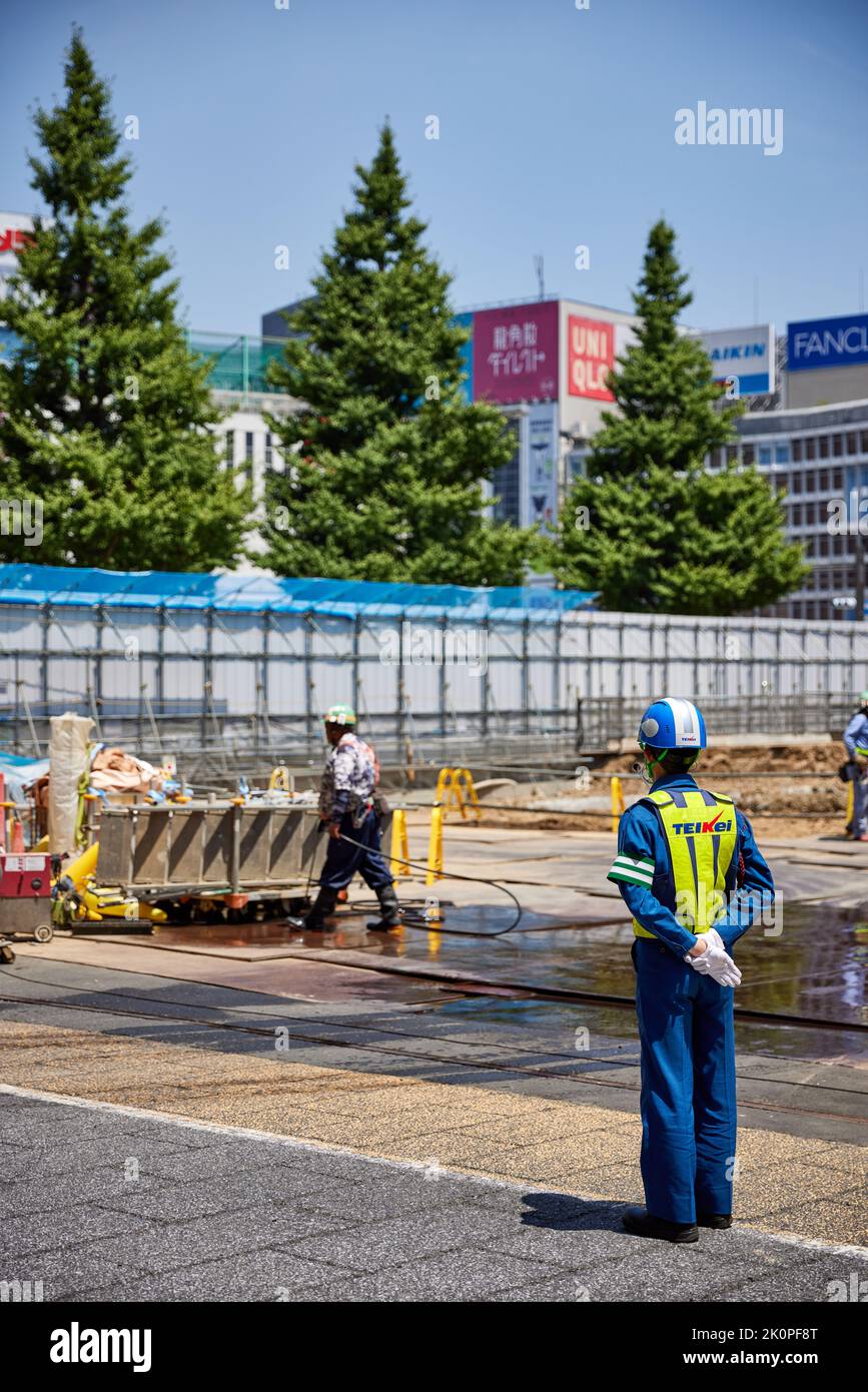 Wache in Uniform und Helm auf der Baustelle beim Bahnhof Shinjuku, Tokio, Japan Stockfoto