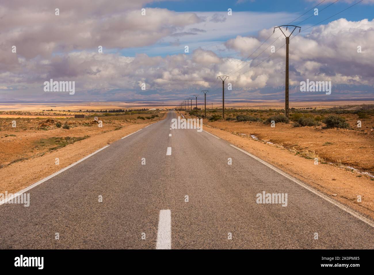 Endlose Asphaltstraße in trockenem Stein Marokko Wüste Stockfoto