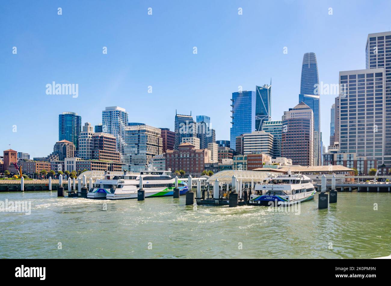 San Francisco Bay Ferries dockten im Hafen der San Francisco Ferry Port mit der Skyline der Stadt dahinter an. Stockfoto