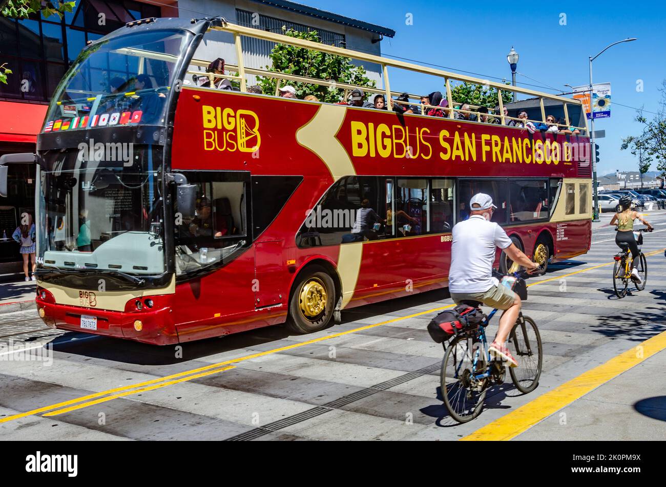 A Big Bus Tours Open-copped Tour Bus in San Francisco, Kalifornien an einem Sommertag, an dem Radfahrer vorbeifahren Stockfoto