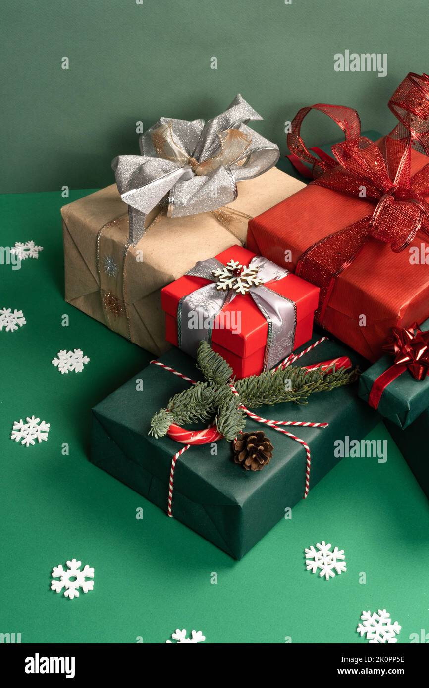 Weihnachtliche Naturdekorationen, rote Kugeln, Geschenkbox und Notizblock auf grünem Hintergrund. Weihnachtsgruß-Design. Vorderansicht. Das Konzept von Urlaub und Neujahr. Stockfoto
