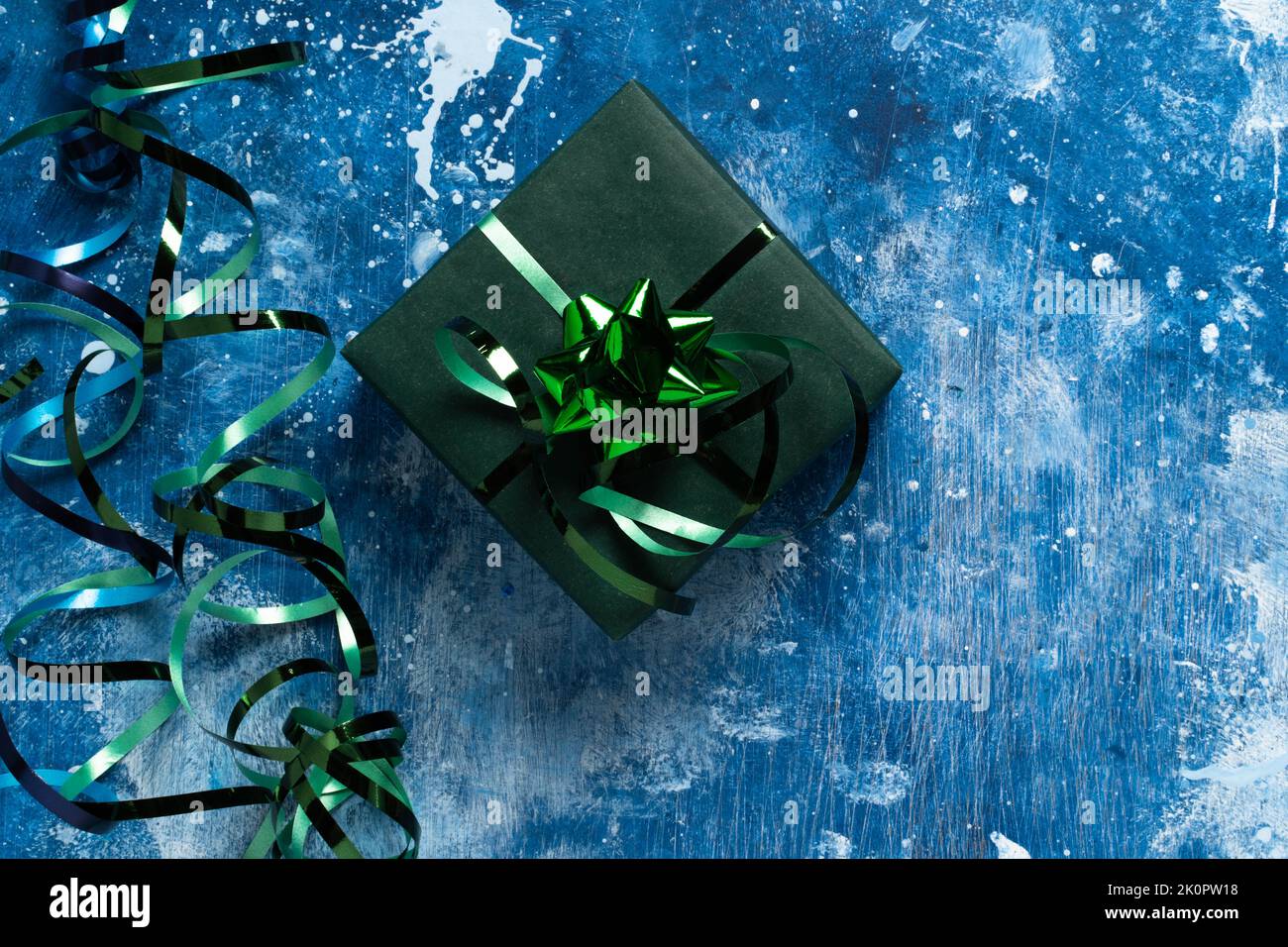 Festliche Feiertage Neujahr und Weihnachten grüne Geschenkbox auf blauem abstrakten Hintergrund. Konzept von Karneval, Geburtstag, Party. Copy Space , guter Hintergrund für Ihr Design. Flach liegend. Draufsicht Stockfoto