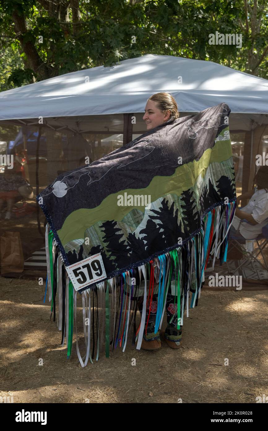 In voller Länge Porträt eines Mitglieds der indianischen Mohegan-Indianer, das einen handgefertigten, gefransten Schal trägt. Beim Shinnecock Powwow 2022. Stockfoto