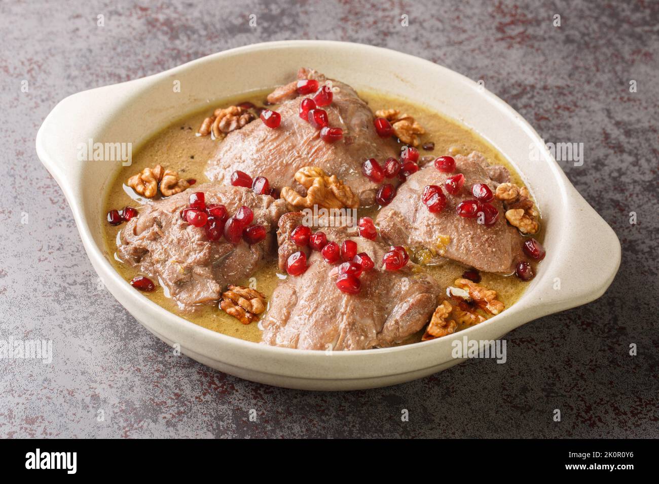 Fesenjan ist ein einfacher, langsam gekochter iranischer Eintopf mit gemahlenen Walnüssen, Granatapfelmelasse und Hühnerschenkeln in einer Pfanne auf dem Tisch. Hori Stockfoto