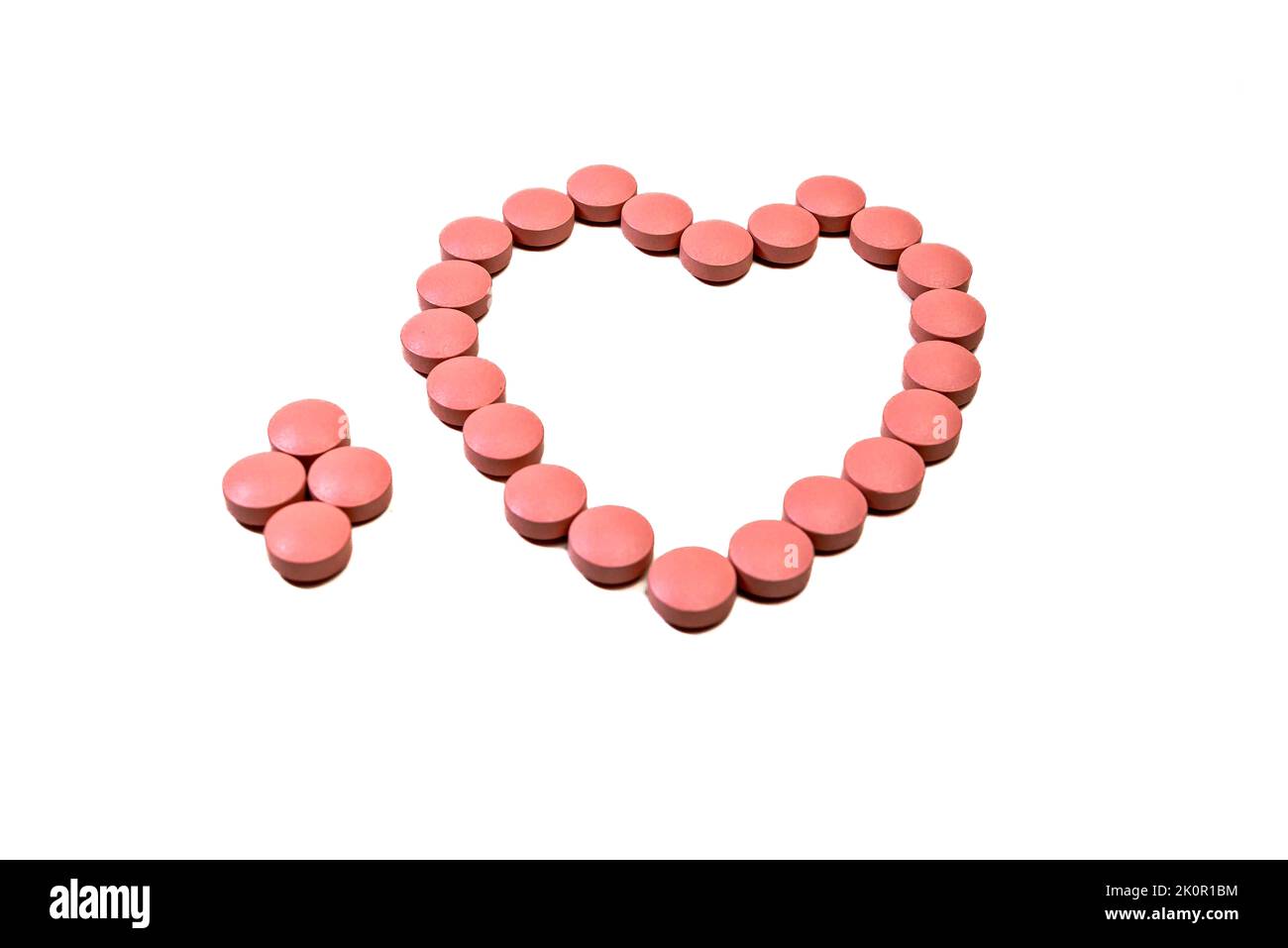 Rosa Pillen bilden ein Herz. Apotheker, Medizin Stockfoto