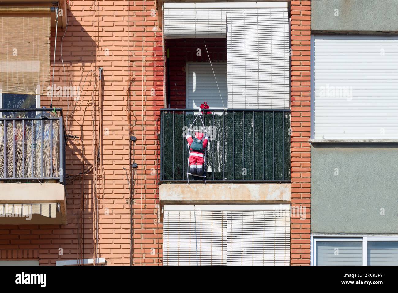 Bild eines kleinen Weihnachtsmanns, der zu Weihnachten von einem Balkon gehängt wurde Stockfoto