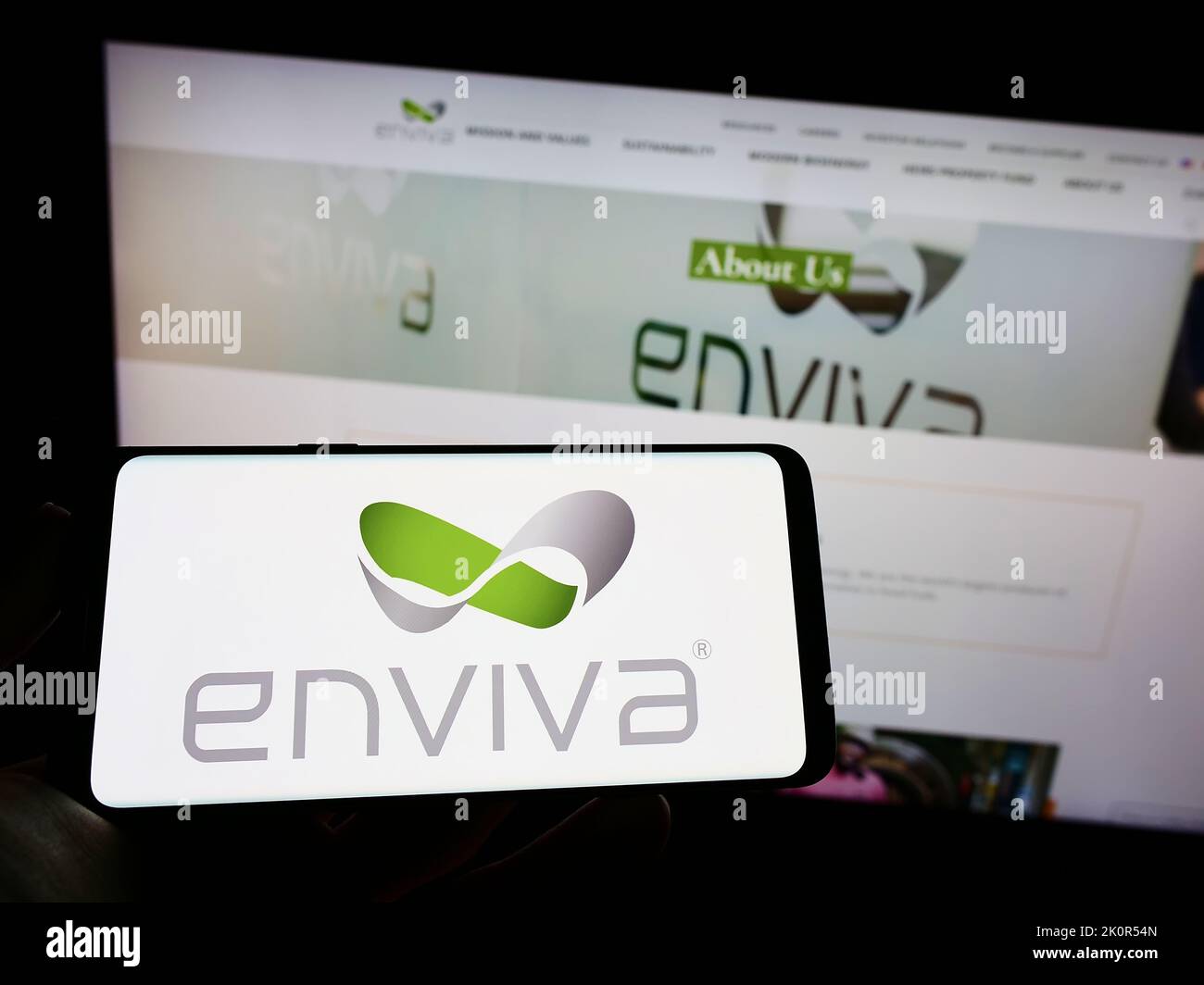 Person, die Mobiltelefon mit dem Logo der US-Holzpellet-Firma Enviva Inc. Auf dem Bildschirm vor der Business-Webseite hält. Konzentrieren Sie sich auf die Telefonanzeige. Stockfoto