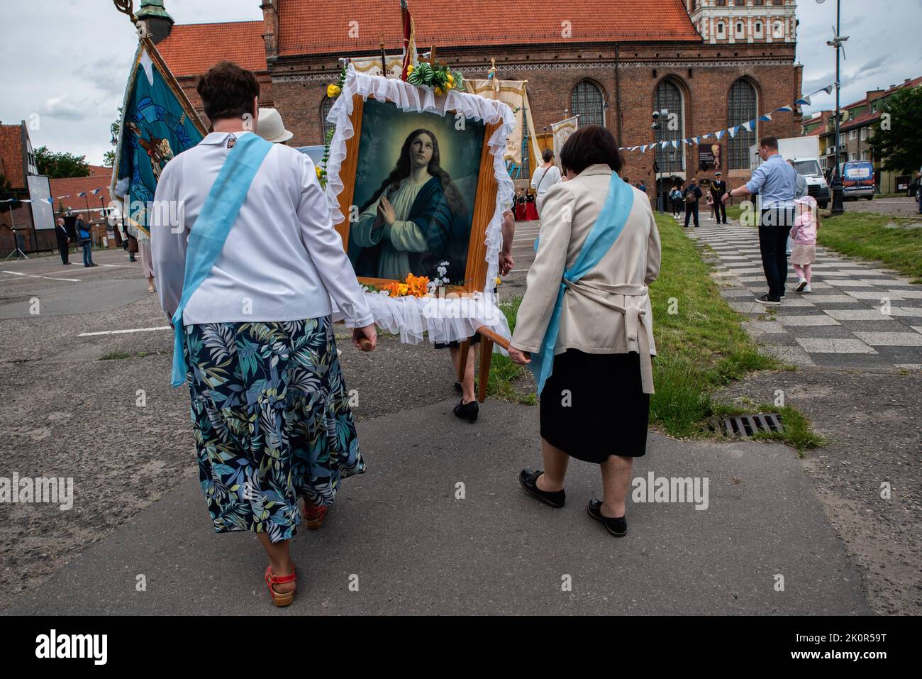 Frauen sehen, wie sie ein Porträt von Jesus Christus tragen. Fronleichnam - liturgische Feier in der katholischen Kirche zu Ehren Jesu Christi im Allerheiligsten Sakrament. Eine Prozession von Gläubigen ging durch die Straßen von GDA?sk. Stockfoto