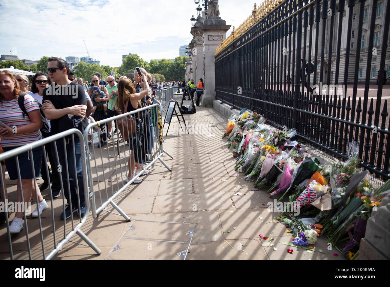 LONDON, Großbritannien - 2022. September: Blumen werden an den Toren des Buckingham Palace zu Ehren von Königin Elizabeth II. Hinterlassen Stockfoto