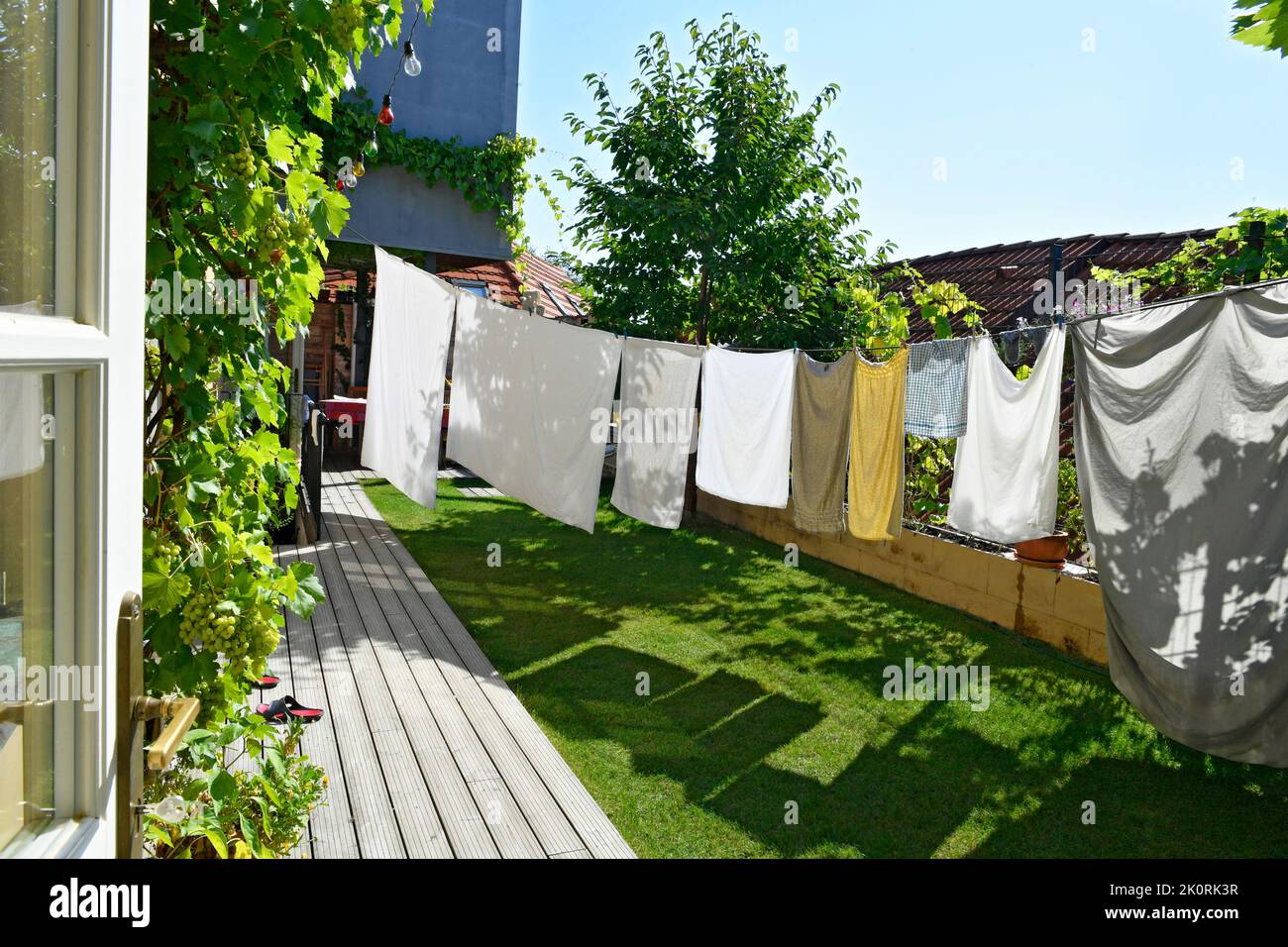 Sonniger Sommertag in kleinem Hof mit Haushaltswäsche auf Wäscheleine Stockfoto