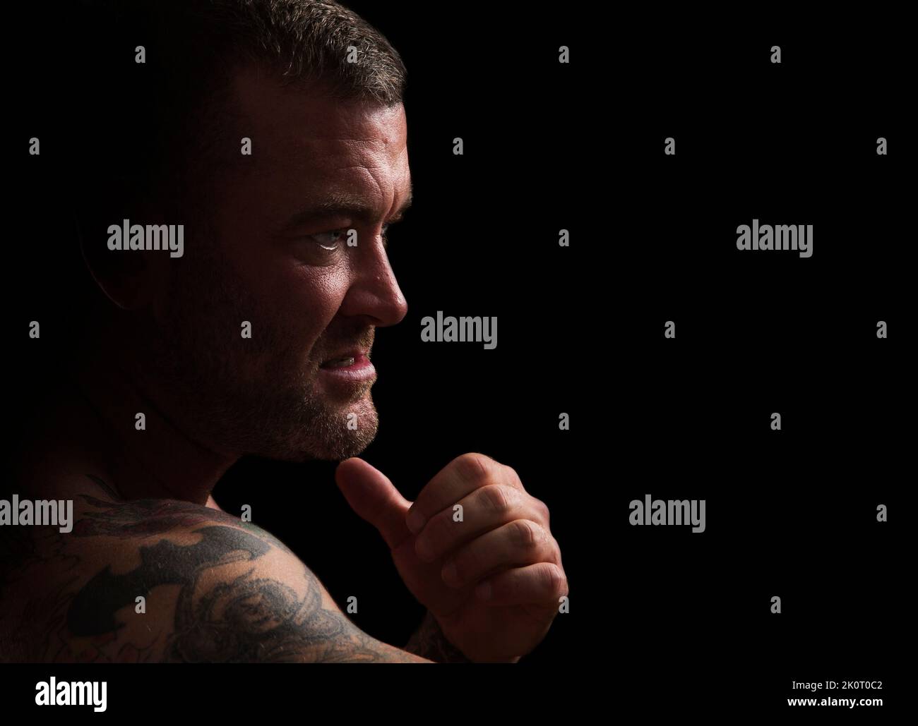 Erwachsener Mann, der einen wütenden, gemeinen Blick mit seiner Faust zum Schließen gibt. Stockfoto