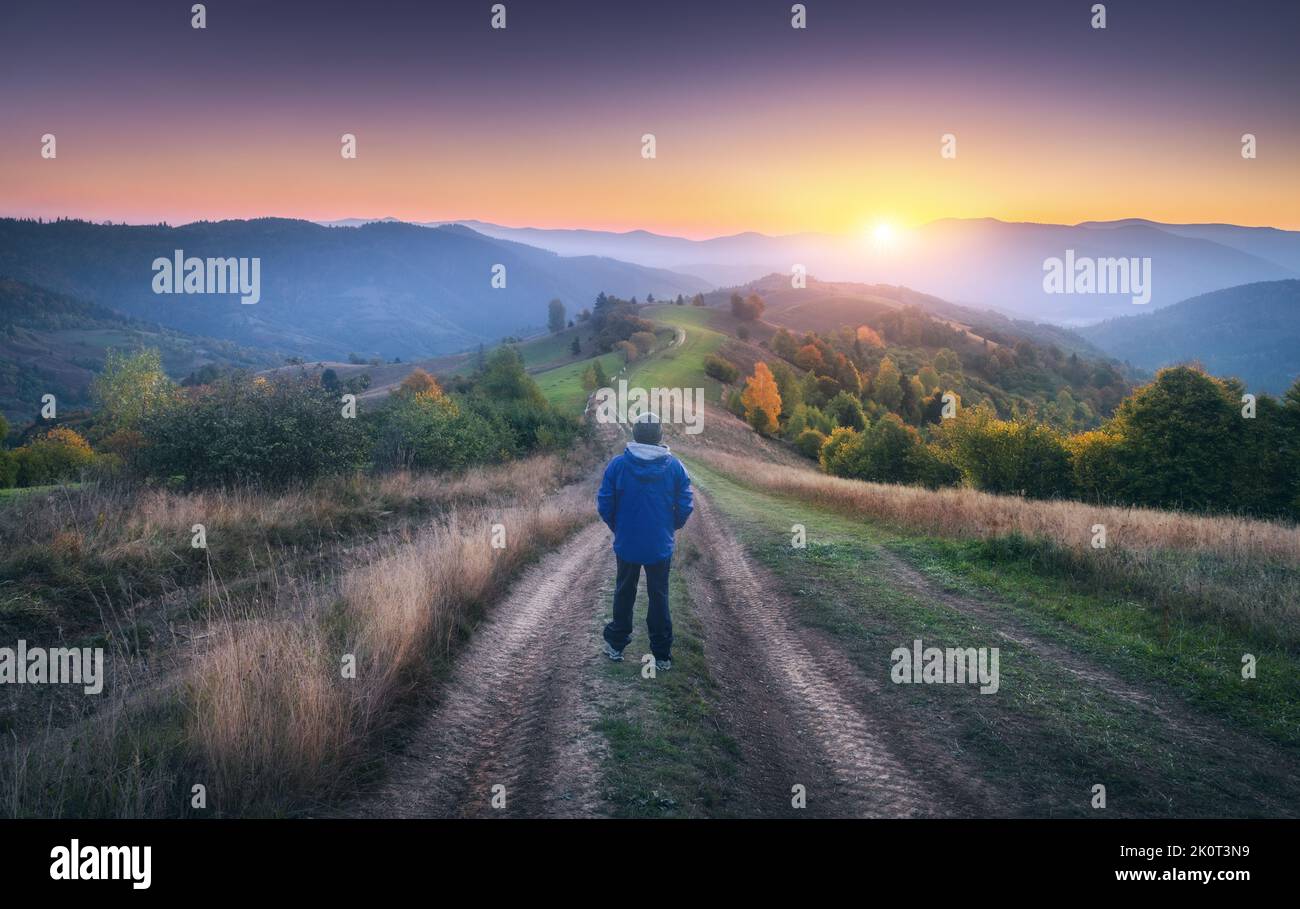 Mann auf dem ländlichen Feldweg auf dem Hügel, der im Nebel auf den Berg blickt Stockfoto