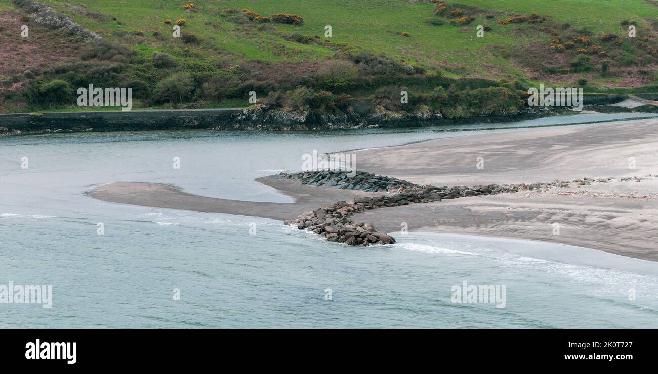 Ein Steindamm am Ufer des Atlantischen Ozeans. Küstenlandschaft. Warren Beach. Grünes Grasfeld in der Nähe des Wassers Stockfoto