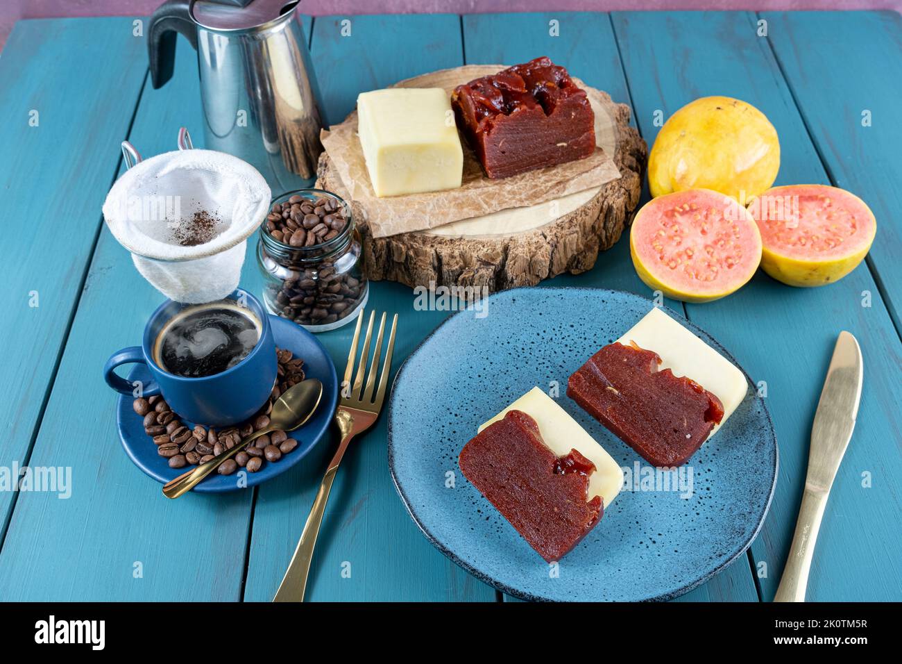 Guava süß mit Käse, umgeben von Tasse und Kaffeebohnen auf einem blauen Tisch Stockfoto