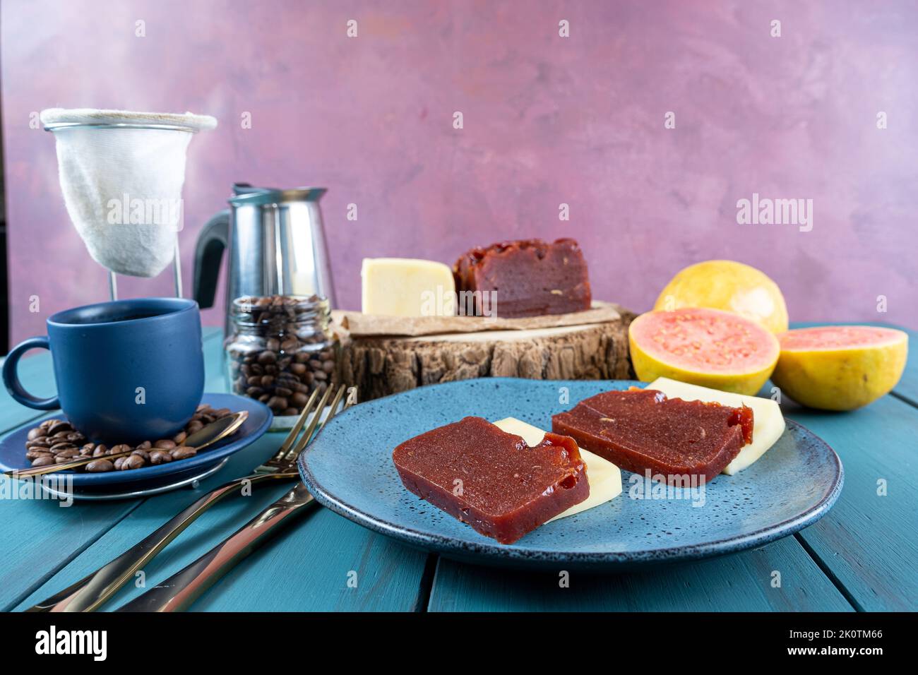 Guava süß mit Käse, umgeben von einer Tasse und Kaffeebohnen auf einer blauen Tischseite. Stockfoto