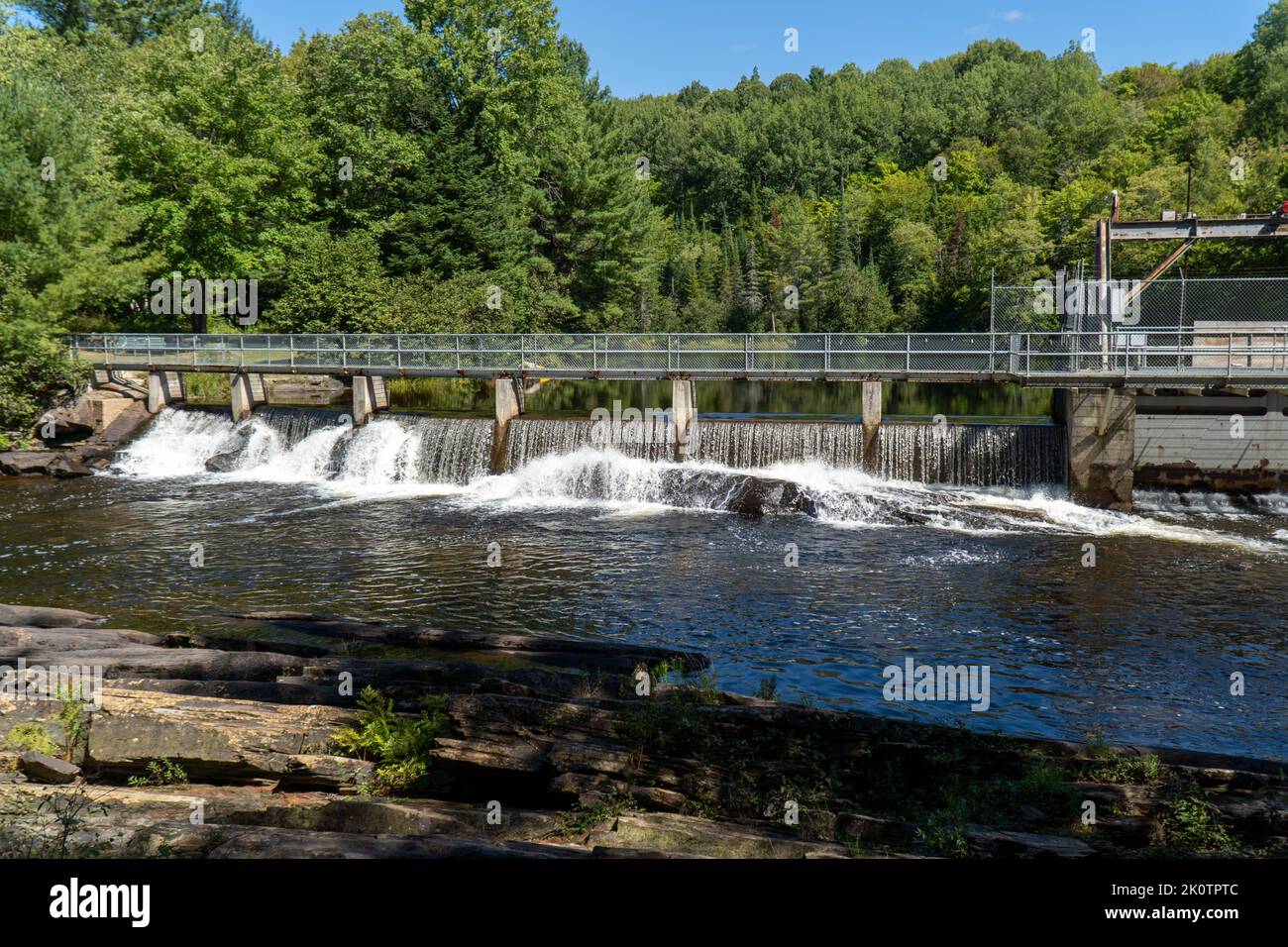 Wasser fließt über alten Damm in Cottage County an einem sonnigen Sommernachmittag. Stockfoto