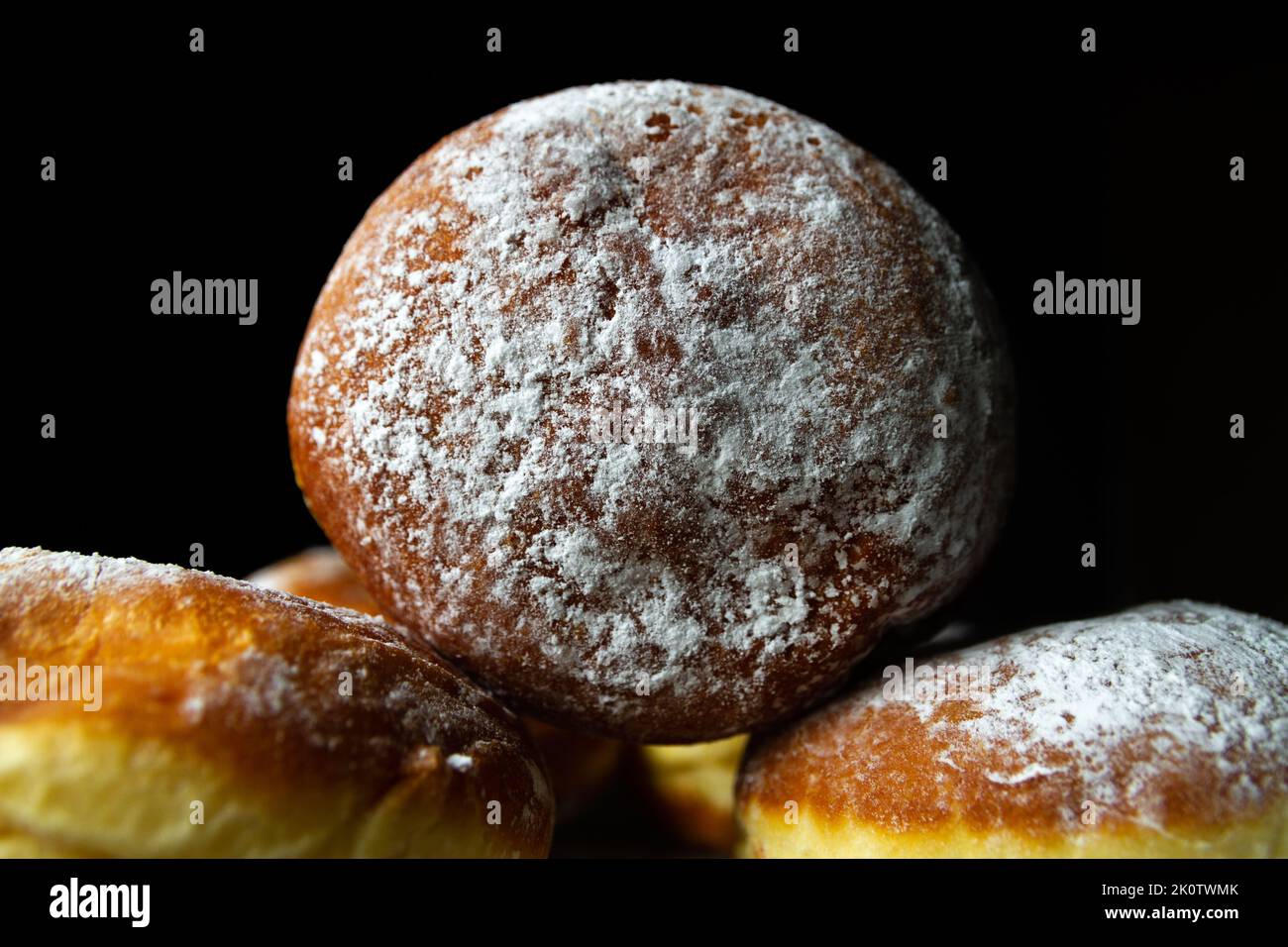 Polnische, frittierte pączki-Donuts. Fat Thursday (Tłusty czwartek) Festmahl, traditioneller Tag in Polen. Pączek Essen mit Puderzucker, Rosenhüftmarmelade. Stockfoto