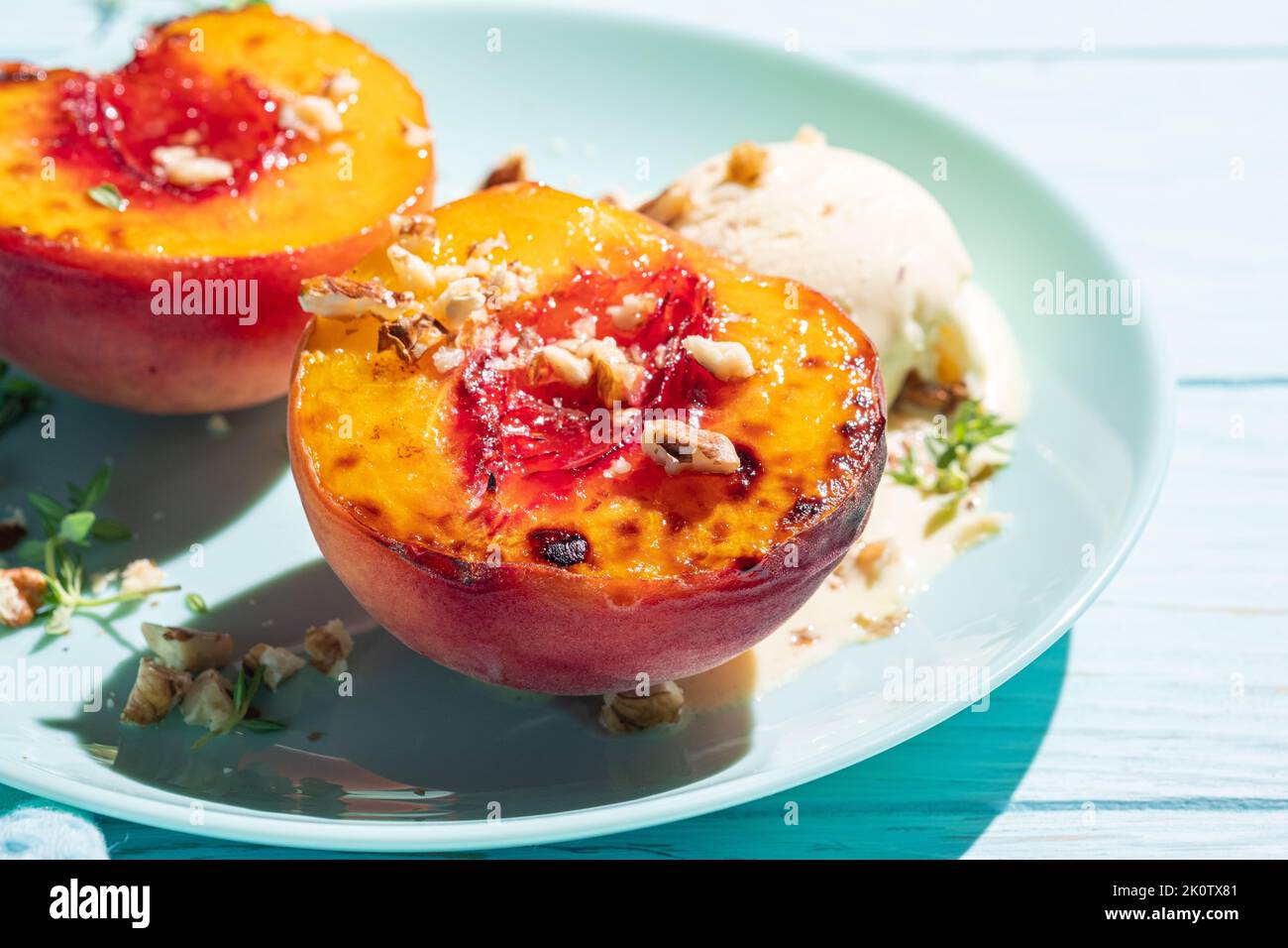 Gegrillte Pfirsiche mit Vanilleeis und Honig. Stockfoto