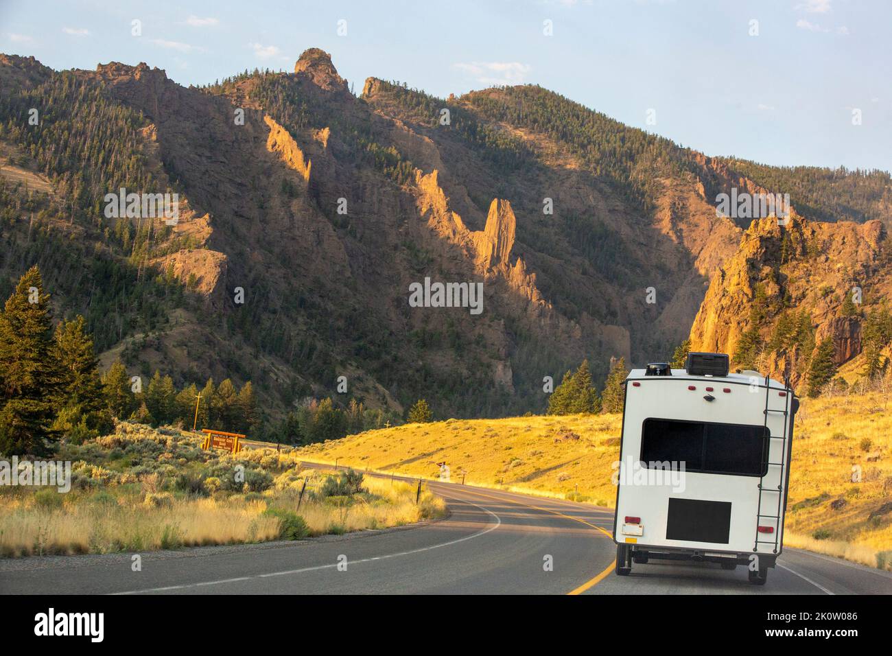 Ein Wohnmobil-Anhänger auf einem Highway bei Sonnenaufgang in den Absaroka Mountains, der entlang der North Fork des Shoshone River ging, ging zum Yellowstone Park. Stockfoto