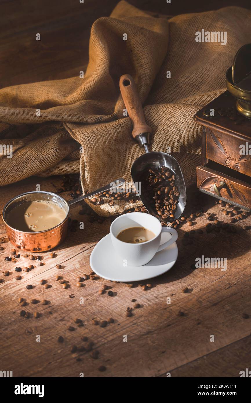 Tasse Latte-Kaffee mit Kanne und Kaffeebohnen Stockfoto