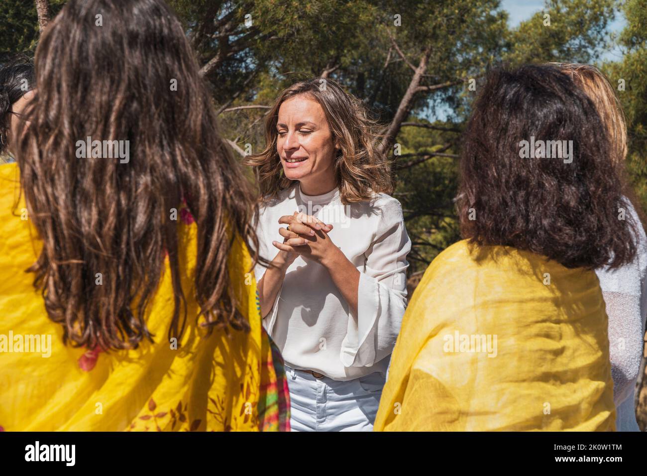 Frauen auf einer Achtsamkeitsgruppentherapie im Wald. Coach erklärt Meditation Stockfoto