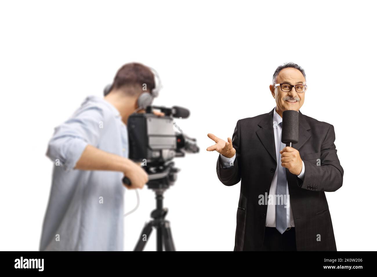 Kameramann, der einen männlichen fernsehmoderator mit einem Mikrofon aufzeichnet, das mit isolierter Hand auf weißem Hintergrund gestikelt wird Stockfoto