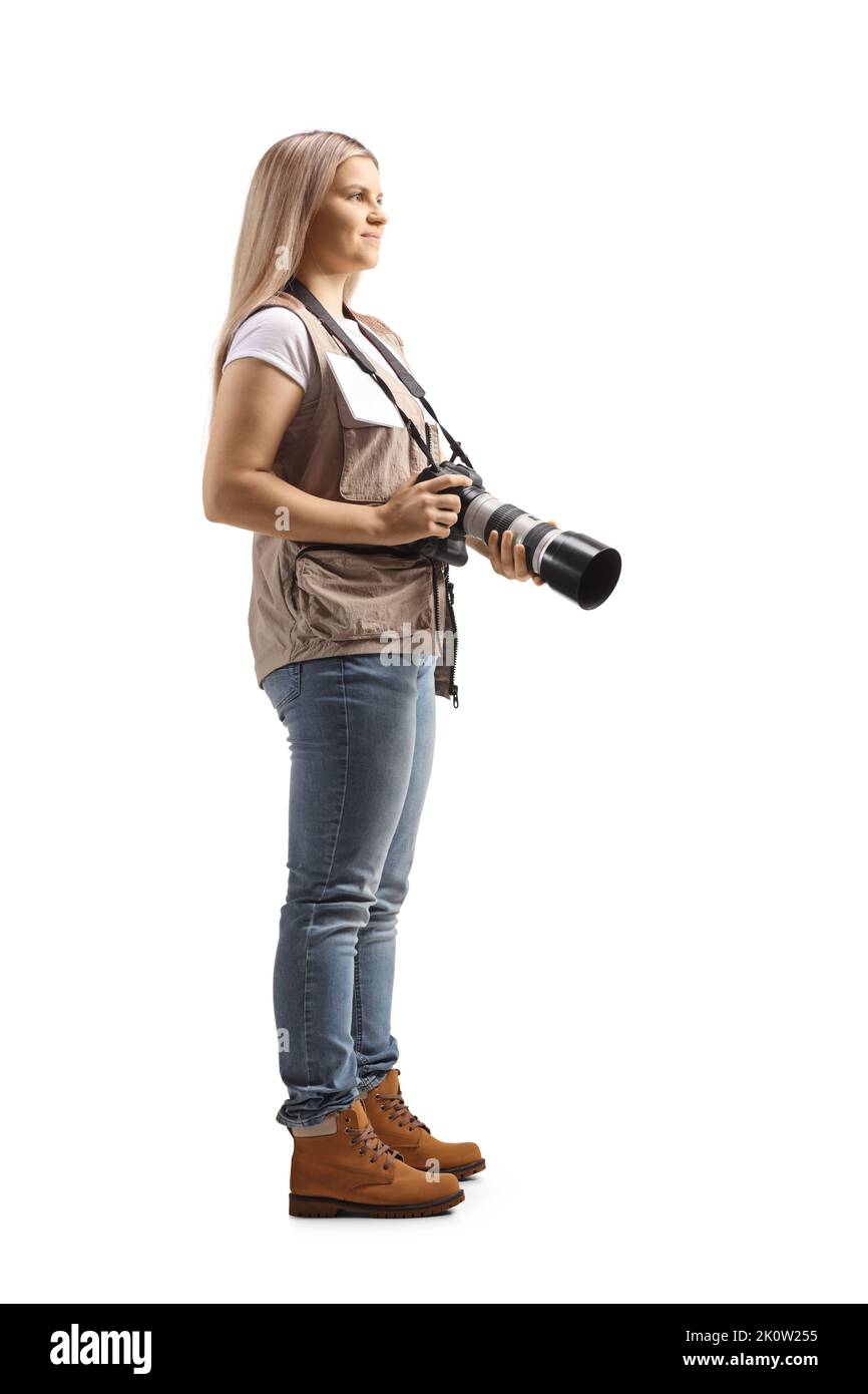 Ganzkörperaufnahme einer jungen Fotografin, die eine isolierte Kamera auf weißem Hintergrund trägt Stockfoto