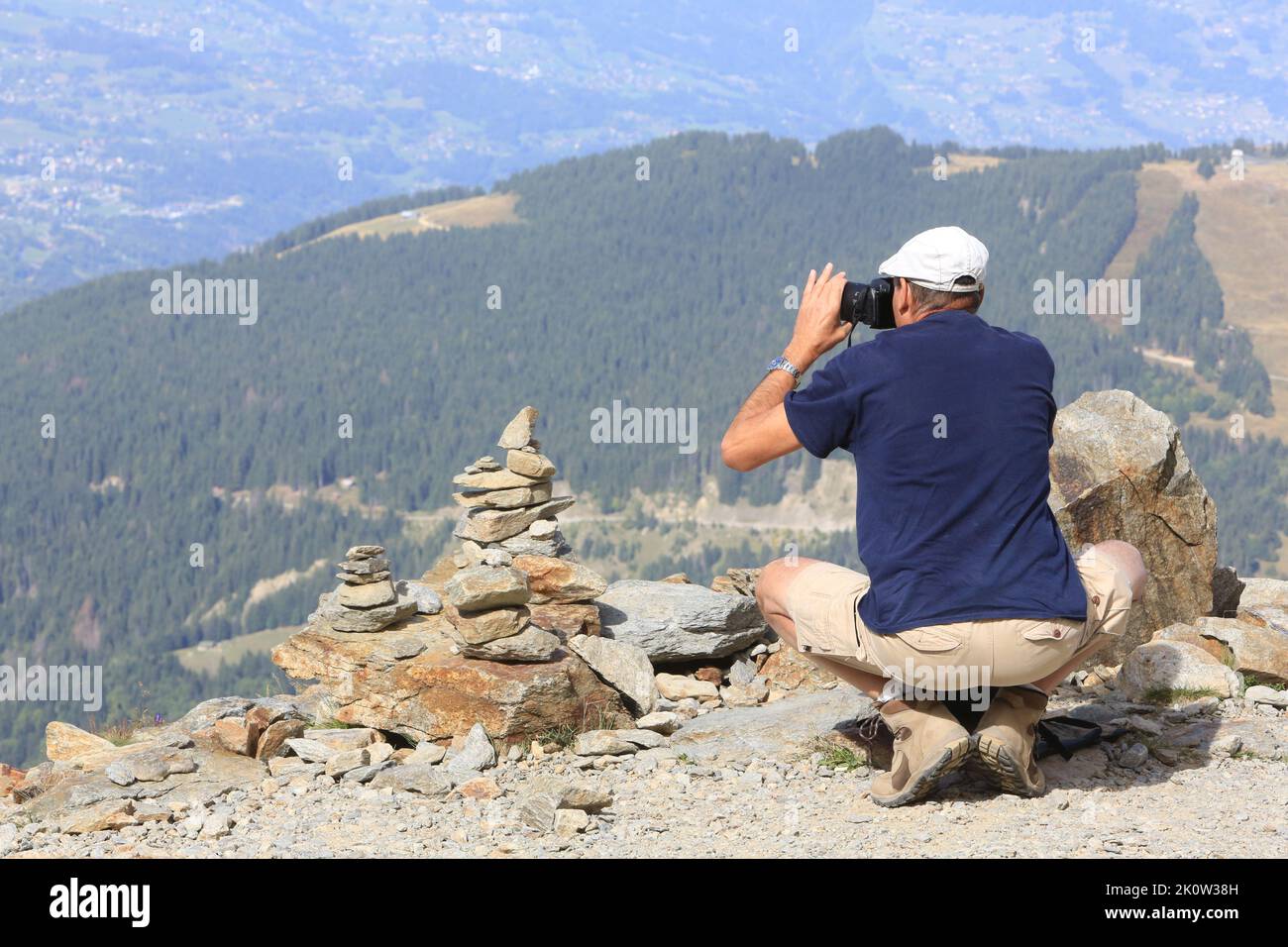 Touriste à proximité d'un cairn, amas de pierres placé pour marquer un lieu particulier, photographiant le paysage. NID d’Aigle. Saint-Gervais-les-Bai Stockfoto