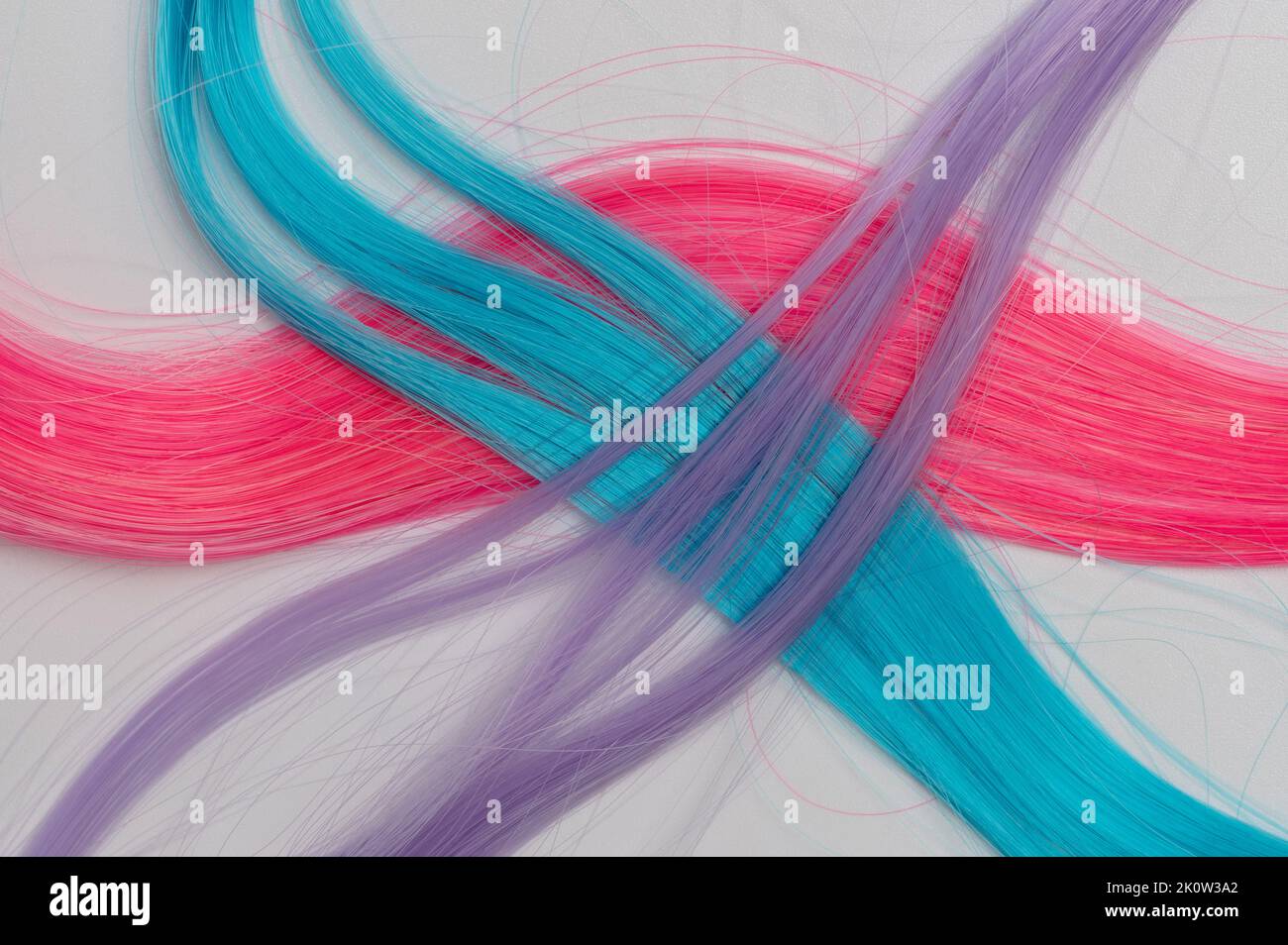 Gekreuzte bunte Haarsträhnen isoliert auf weißem Studiohintergrund Stockfoto