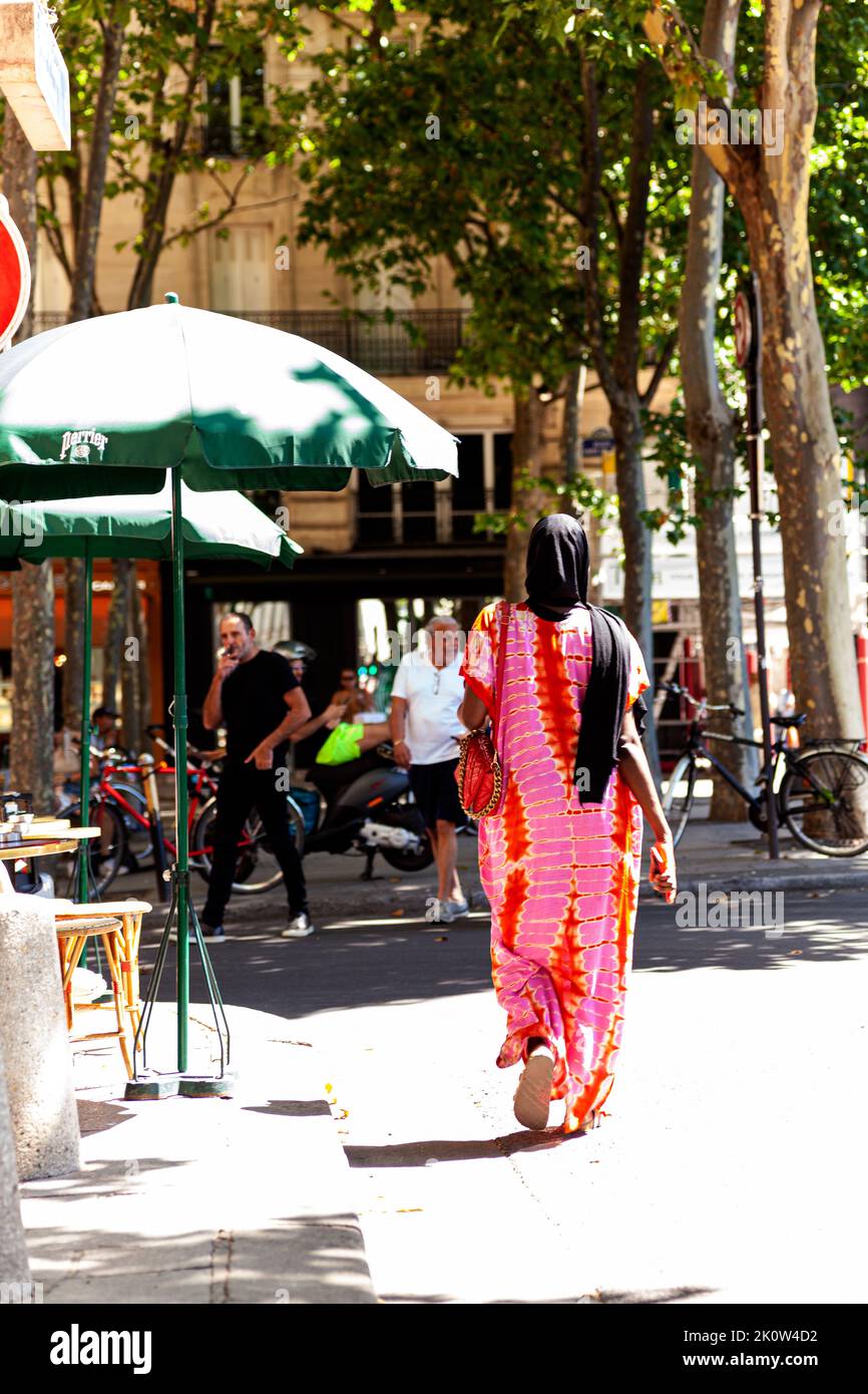 Paris, Frankreich - Juli 15: Rückansicht einer Afrikanerin in farbenfrohem Kleid, die am 15. Juli 2022 auf der Straße von Paris, Frankreich, spazieren ging Stockfoto