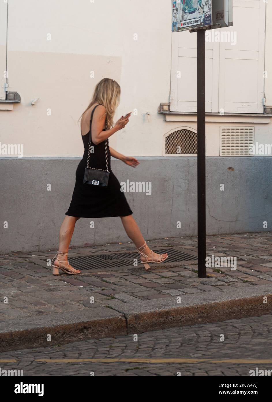 Paris, Frankreich - Juli 15: Junge Frau in engem schwarzen Kleid, die am 15. Juli 2022 in Montmartre zu Fuß unterwegs ist Stockfoto