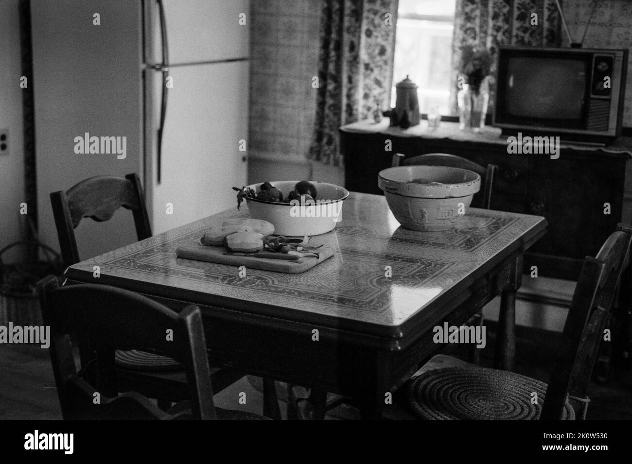 Eine Vintage-Küche mit Speisen auf dem Tisch im Spencer-Peirce-Little 1690 Farmhouse - Newbury, Massachusetts. Das Bild wurde mit analogem Schwarz aufgenommen Stockfoto