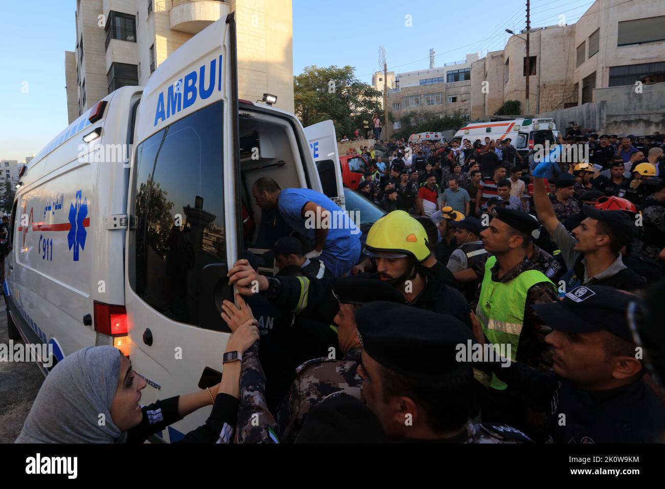 Amman, Jordanien. 13. September 2022. Rettungskräfte überführen ein Opfer in einen Krankenwagen, nachdem am 13. September 2022 ein Wohnhaus in Amman, Jordanien, einstürzte. Die Zahl der Todesopfer beim Einsturz von Wohngebäuden in Amman am Dienstag stieg auf fünf, teilte das Public Security Department (PSD) in einer Erklärung mit. Quelle: Mohammad Abu Ghosh/Xinhua/Alamy Live News Stockfoto