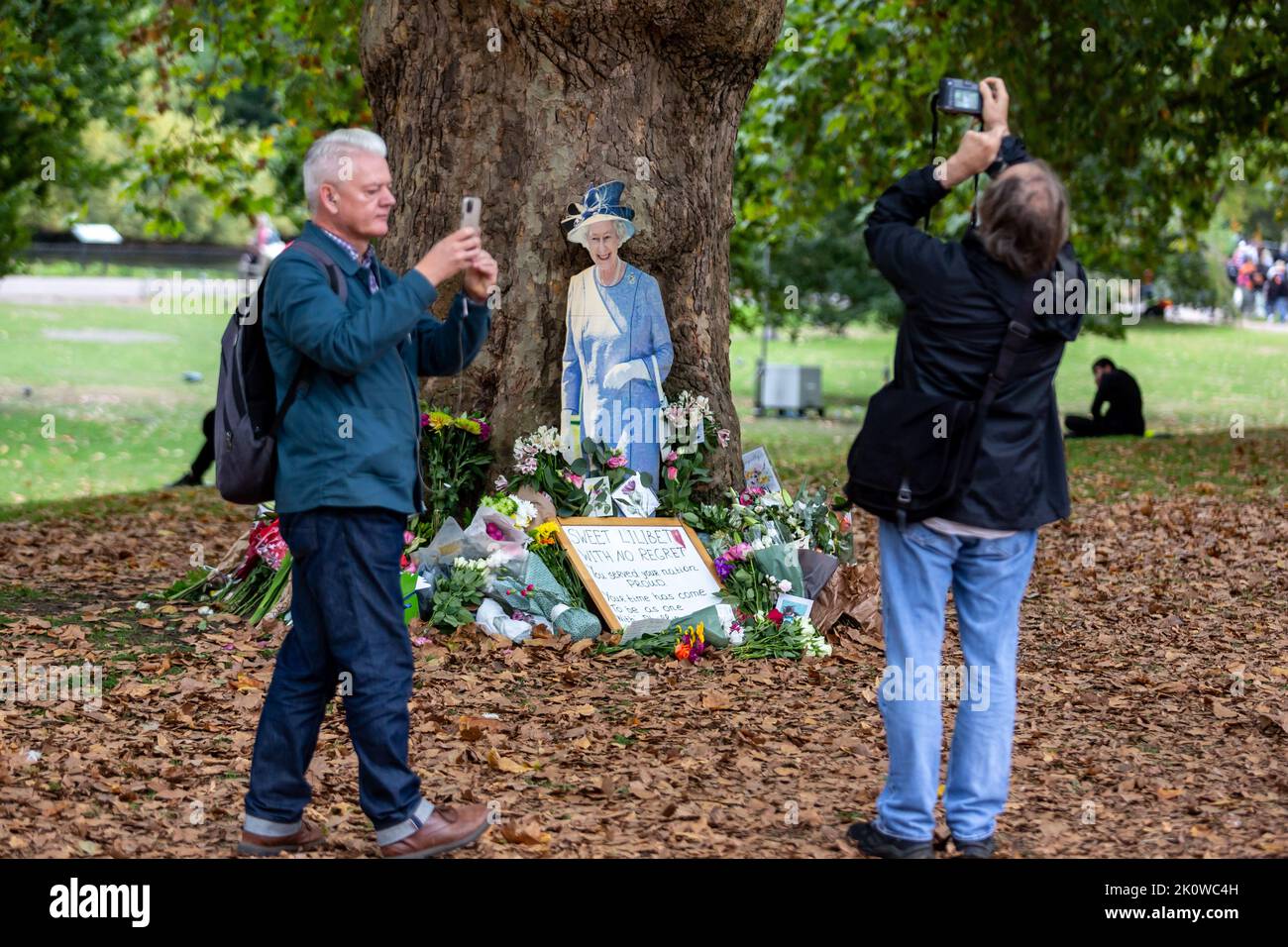 London, Großbritannien. 13. September 2022. Die Menschen fotografieren Blumen und ein Bild der längsten regierenden Monarchin, Königin Elisabeth II., im Saint James's Park, als sie ankommen, um Respekt zu zollen, da der Sarg mit ihrem Körper am 13. September 2022 im Buckingham Palace in London, Großbritannien, ankommen wird. Elisabeth II. Verstarb am 8. September in Schottland. Ihre Überreste nach den Zeremonien in Edinburgh werden am 13. September nach London verlegt und die Öffentlichkeit darf den Palast besuchen, um Respekt zu zollen. (Foto von Dominika Zarzycka/Sipa USA) Quelle: SIPA USA/Alamy Live News Stockfoto