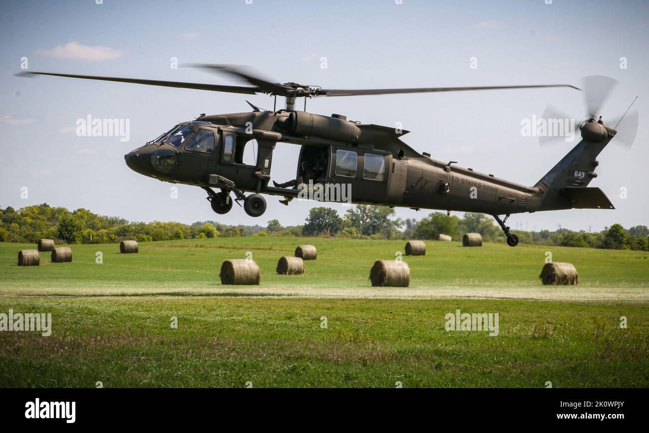 Ein Feld von Heuballen umrahmt einen Iowa Army National Guard UH-60 Black Hawk, der sich auf die Schlinge eines Anhängers während eines U.S. Pathfinder Course am 8. September 2022 in Camp Dodge in Johnston, Iowa, vorbereitet. Fast 30 Soldaten absolvierten den Kurs, der von einem mobilen Trainingsteam im Warrior Training Center der Army National Guard in Fort Benning, Georgia, unterrichtet wurde. Army Pathfinders werden geschult, um Navigationshilfe und Beratungsdienste für Militärflugzeuge in Gebieten zu leisten, die von unterstützten Einheiten-Kommandeuren bestimmt werden. Während des Pathfinder-Kurses werden die Studenten in der Flugzeugorientierung, Aero-Medical ev, unterwiesen Stockfoto