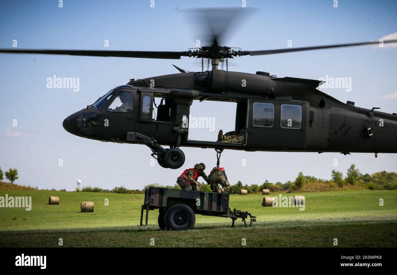 Soldaten der US-Armee hängen einen Anhänger an eine Iowa Army National Guard UH-60 Black Hawk während einer Schlingentraining-Übung im Rahmen eines U.S. Pathfinder Course in Camp Dodge in Johnston, Iowa, am 8. September 2022. Fast 30 Soldaten absolvierten den Kurs, der von einem mobilen Trainingsteam im Warrior Training Center der Army National Guard in Fort Benning, Georgia, unterrichtet wurde. Army Pathfinders werden geschult, um Navigationshilfe und Beratungsdienste für Militärflugzeuge in Gebieten zu leisten, die von unterstützten Einheiten-Kommandeuren bestimmt werden. Während des Pathfinder-Kurses werden die Studierenden in der Flugzeugorientierung Aero-medi eingewiesen Stockfoto