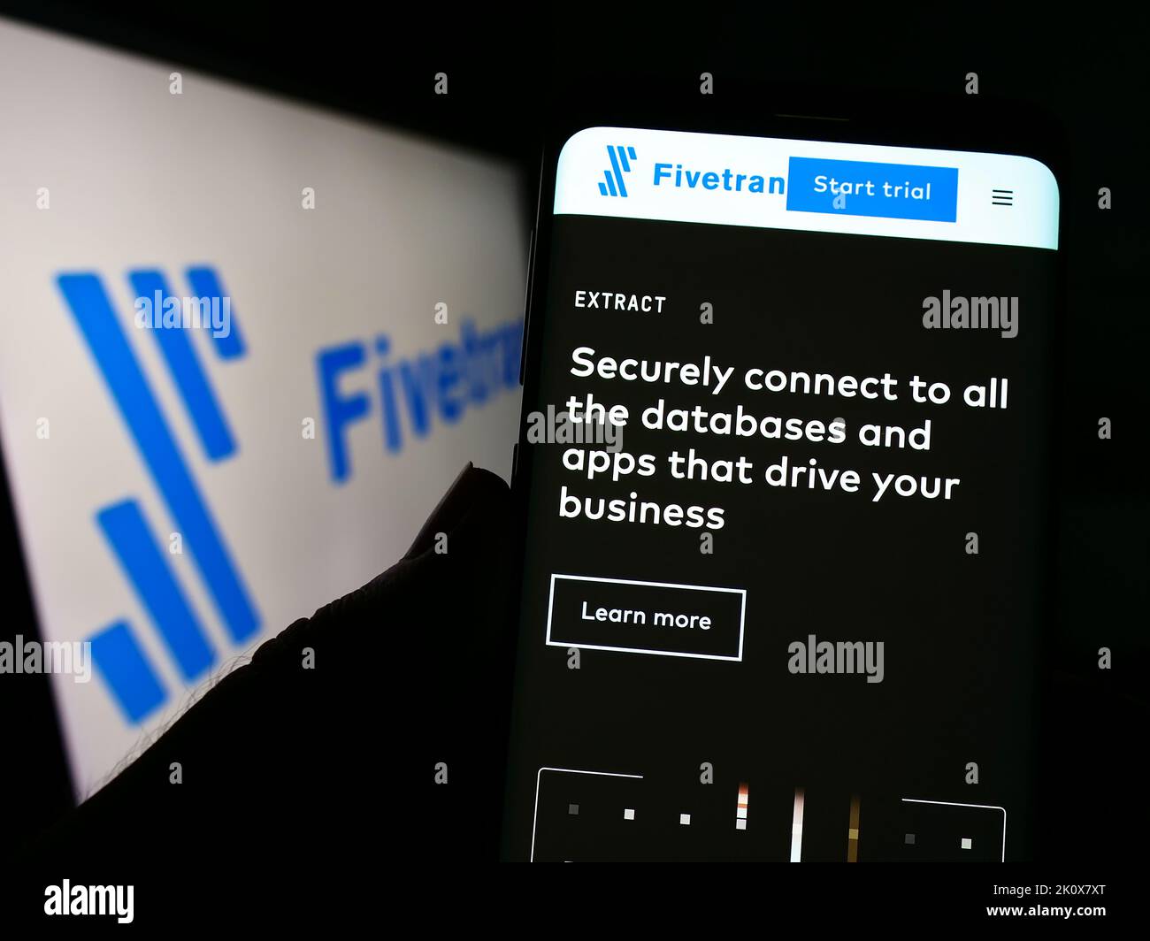 Person, die Mobiltelefon mit der Webseite des amerikanischen Datensoftwareunternehmens Fivetran Inc. Auf dem Bildschirm vor dem Logo hält. Konzentrieren Sie sich auf die Mitte des Telefondisplays. Stockfoto
